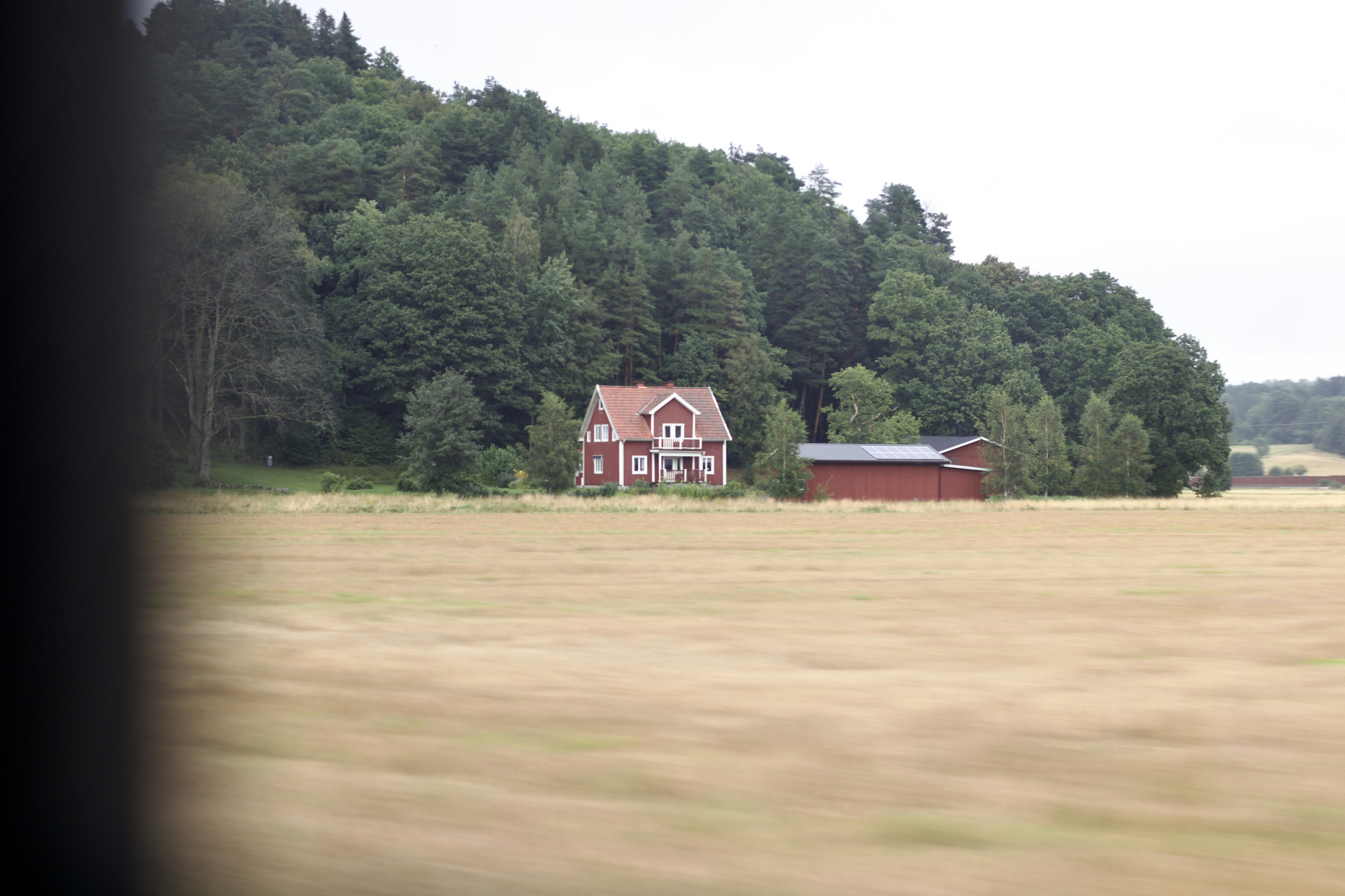 A red barn in a field with trees in the background