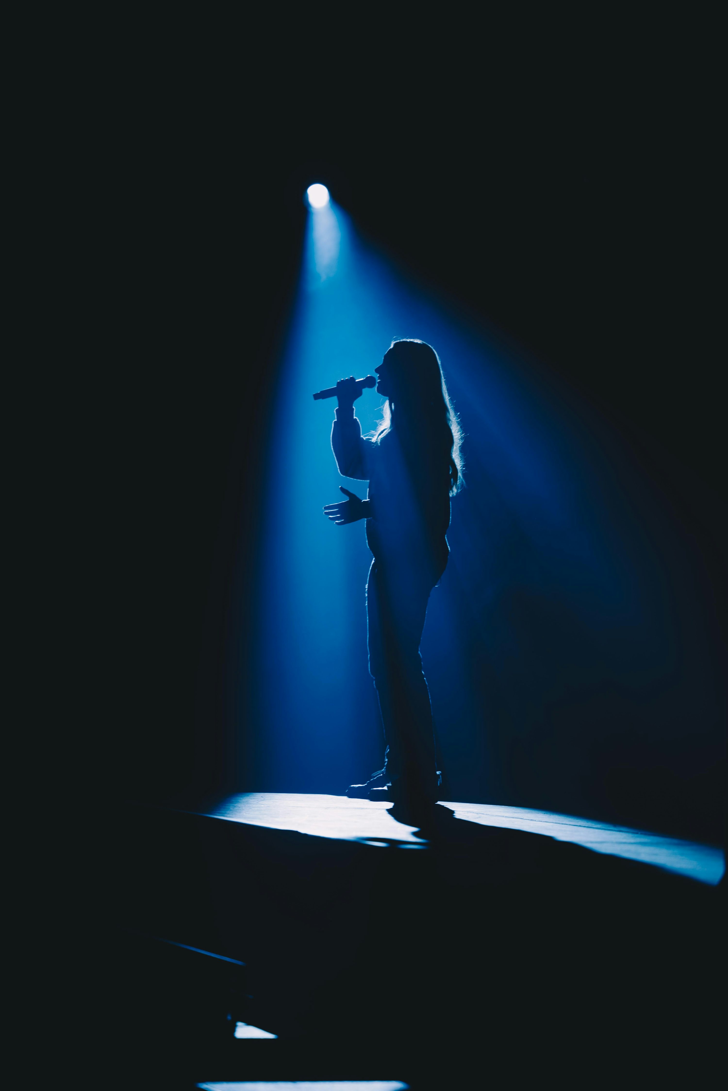 Une personne debout sur une scène avec un micro