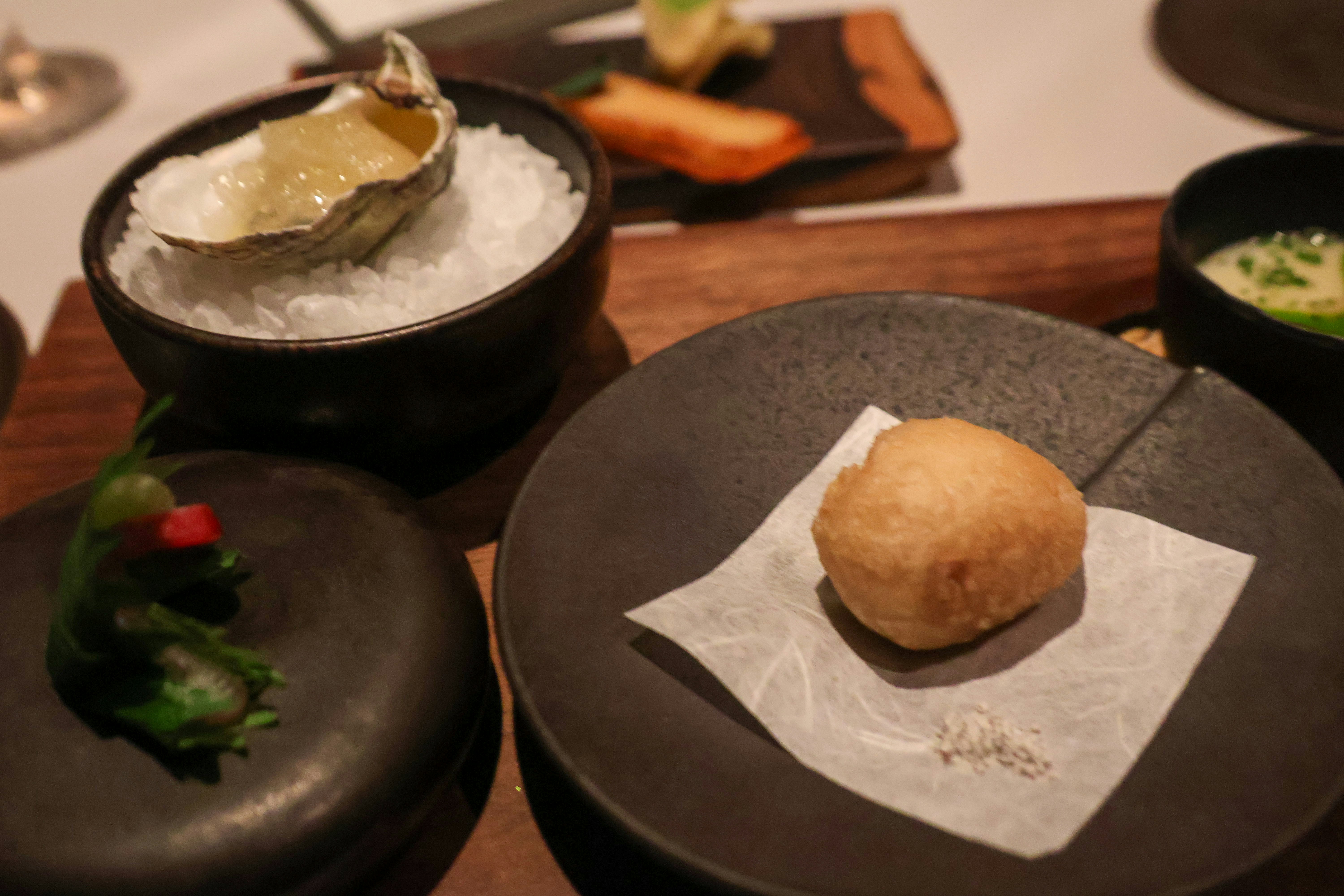 A table topped with black plates filled with food