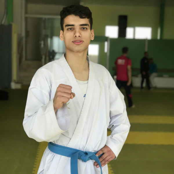 A man standing in a room with a blue belt