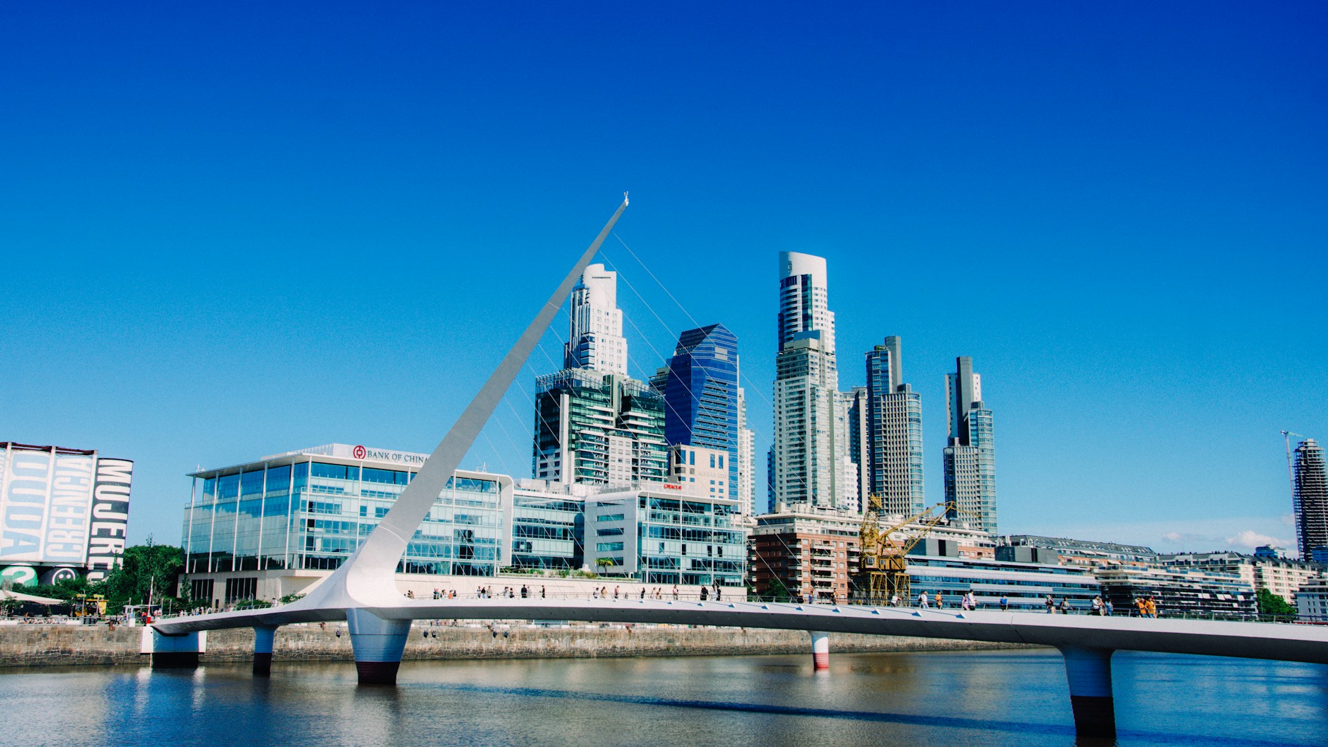 A bridge over a river with a city in the background