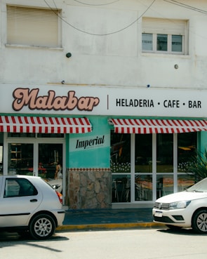 Two cars parked in front of a restaurant