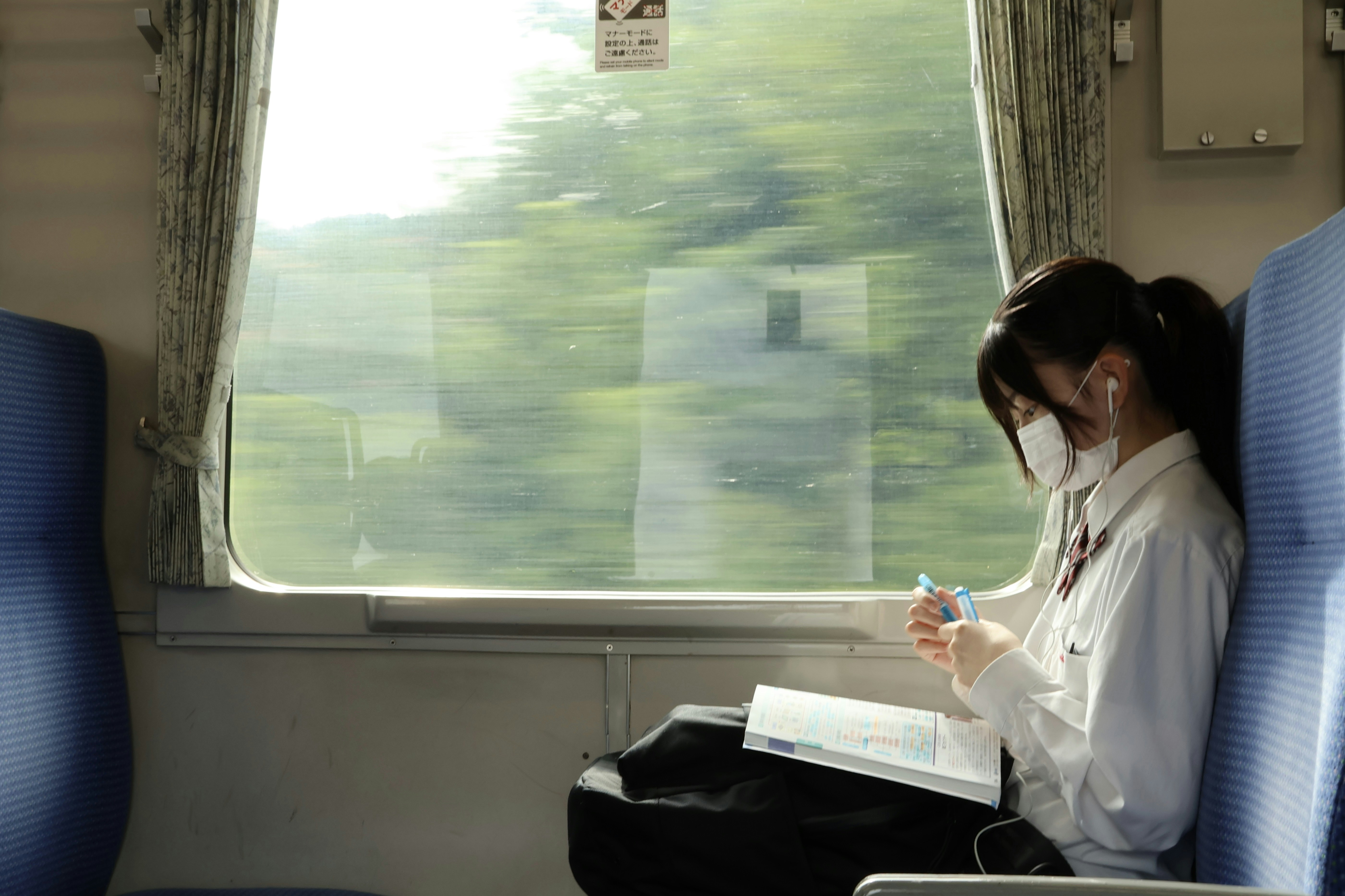 School girl writing her homework on a train