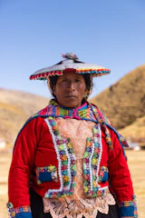 A woman wearing a colorful hat standing in a field