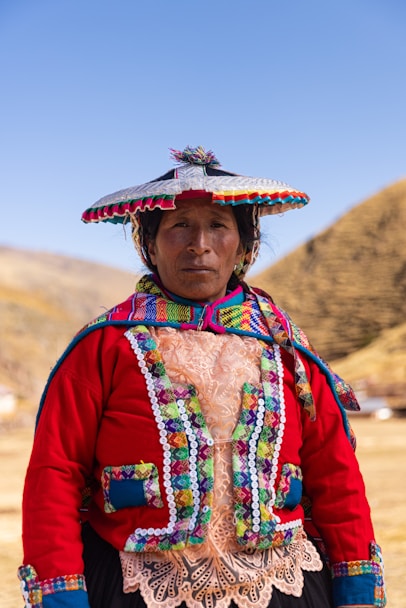 A woman wearing a colorful hat standing in a field
