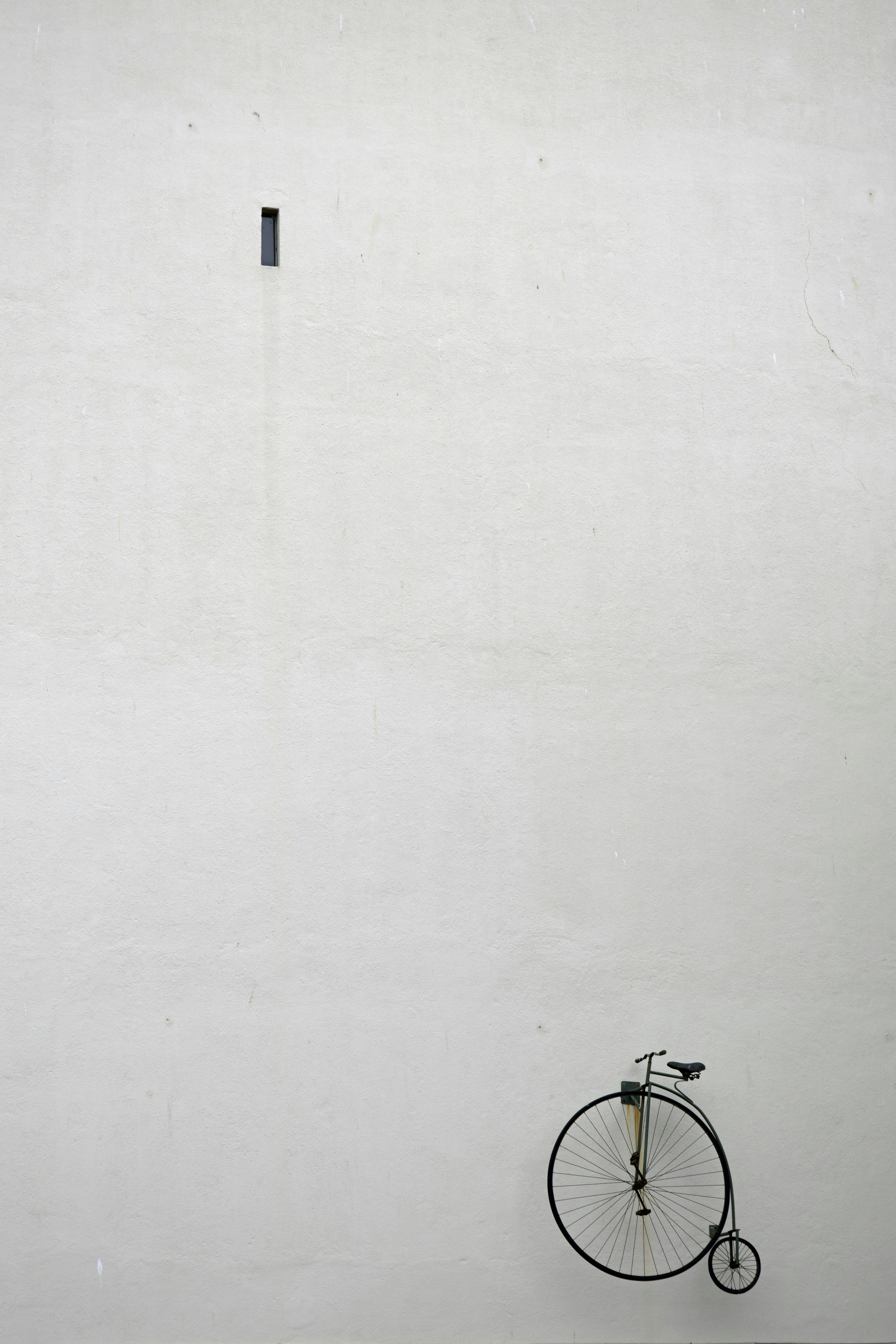 Uma bicicleta encostada em uma parede branca