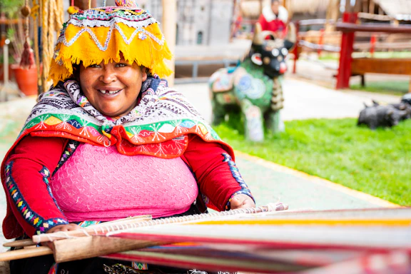 A woman in a colorful headdress holding a surfboard