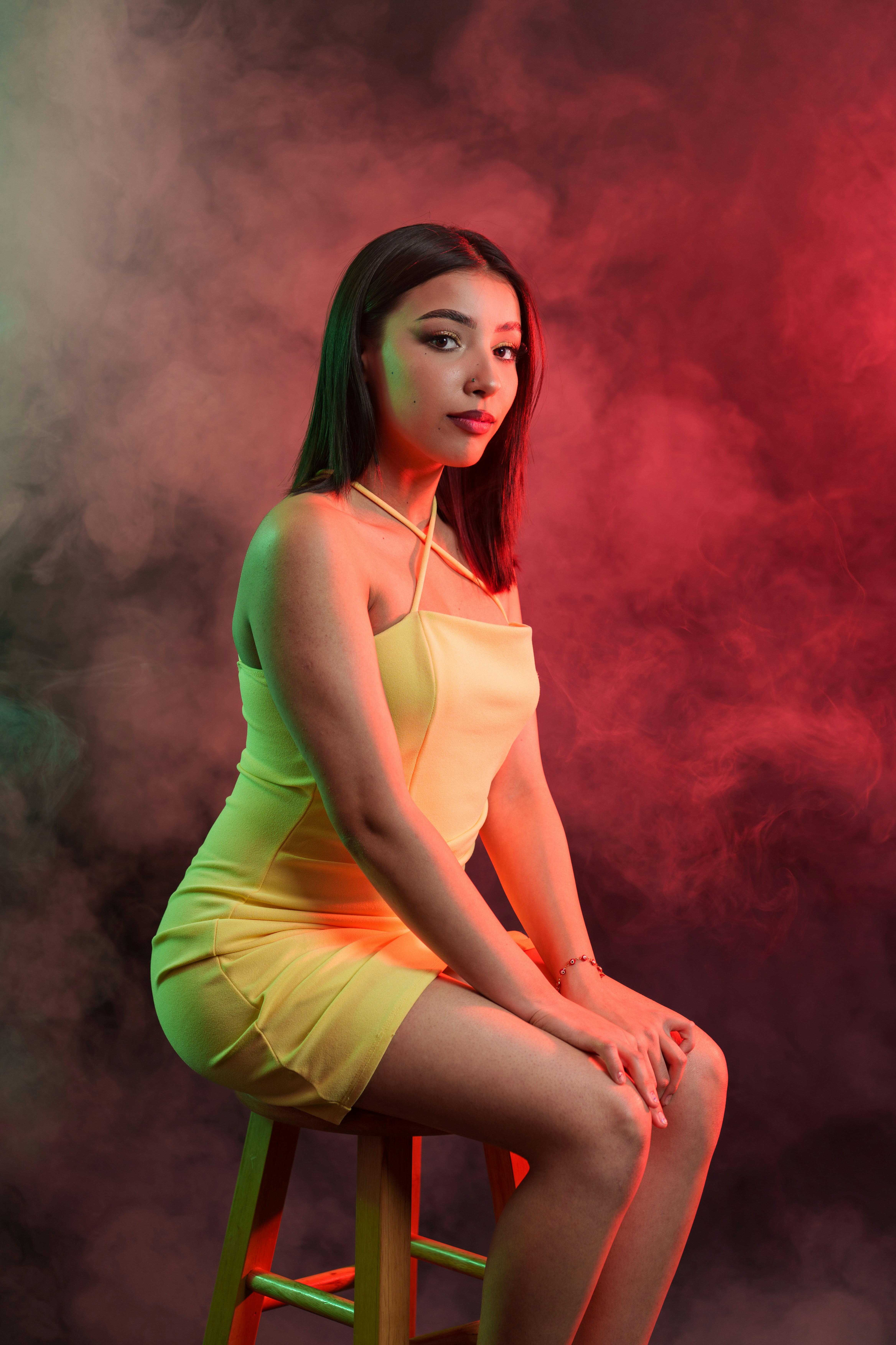 A woman in a yellow dress sitting on a stool