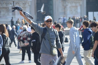 A man with a bird on his arm in the middle of a crowd of people