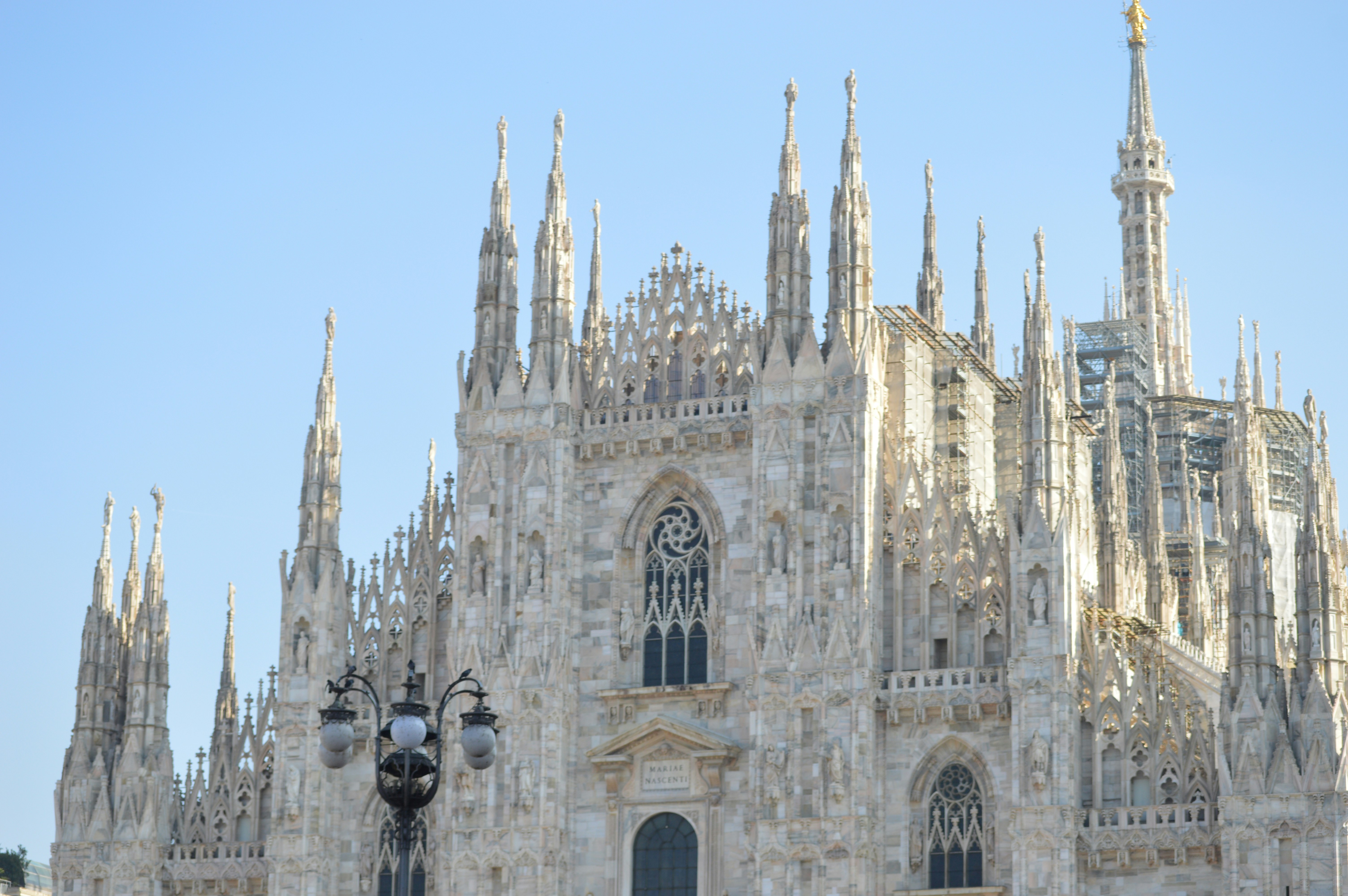 A large cathedral with a clock on the front of it, Essence of Milan, Italy, through its bustling streets, These images highlight the city