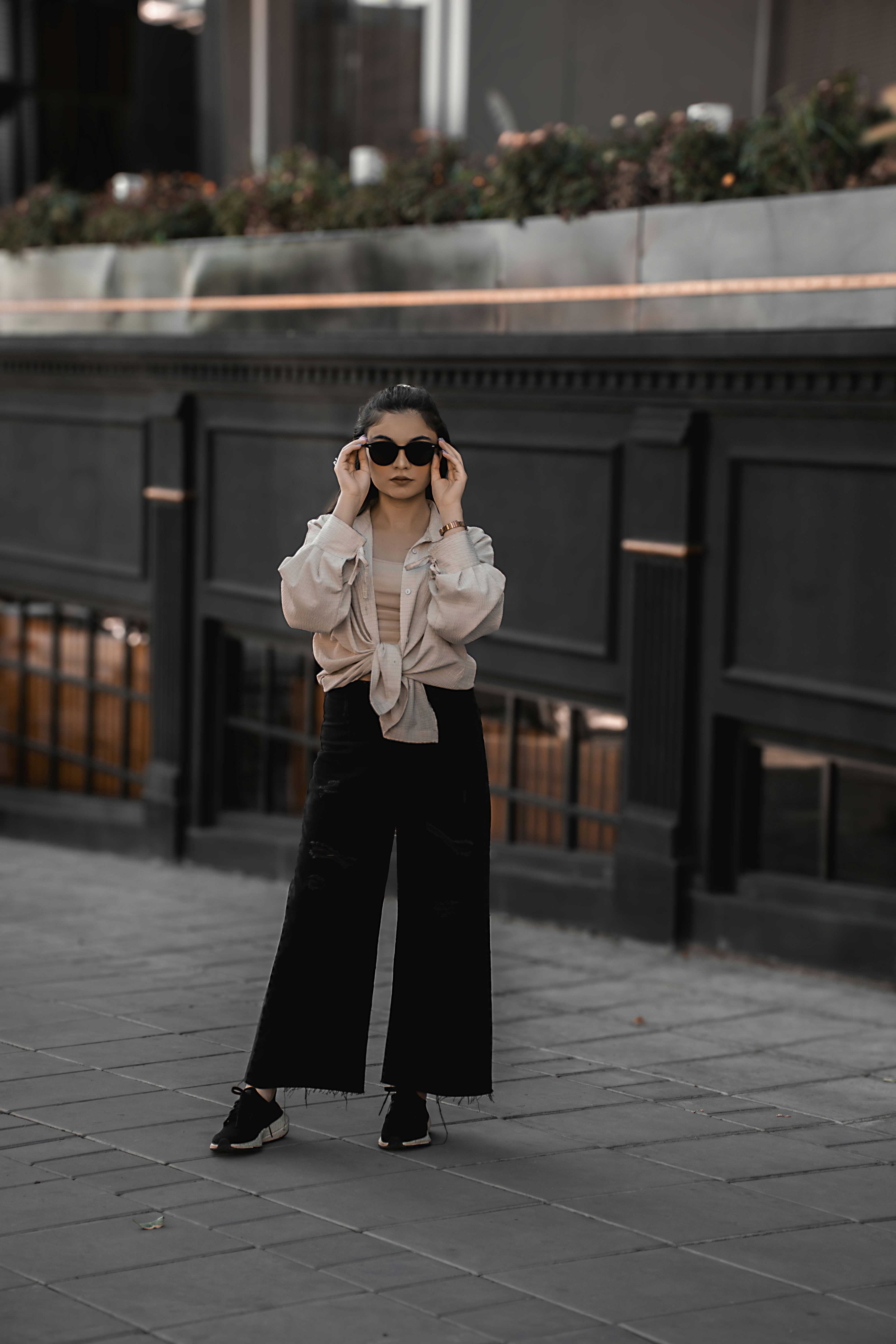 A woman standing on a sidewalk talking on a cell phone