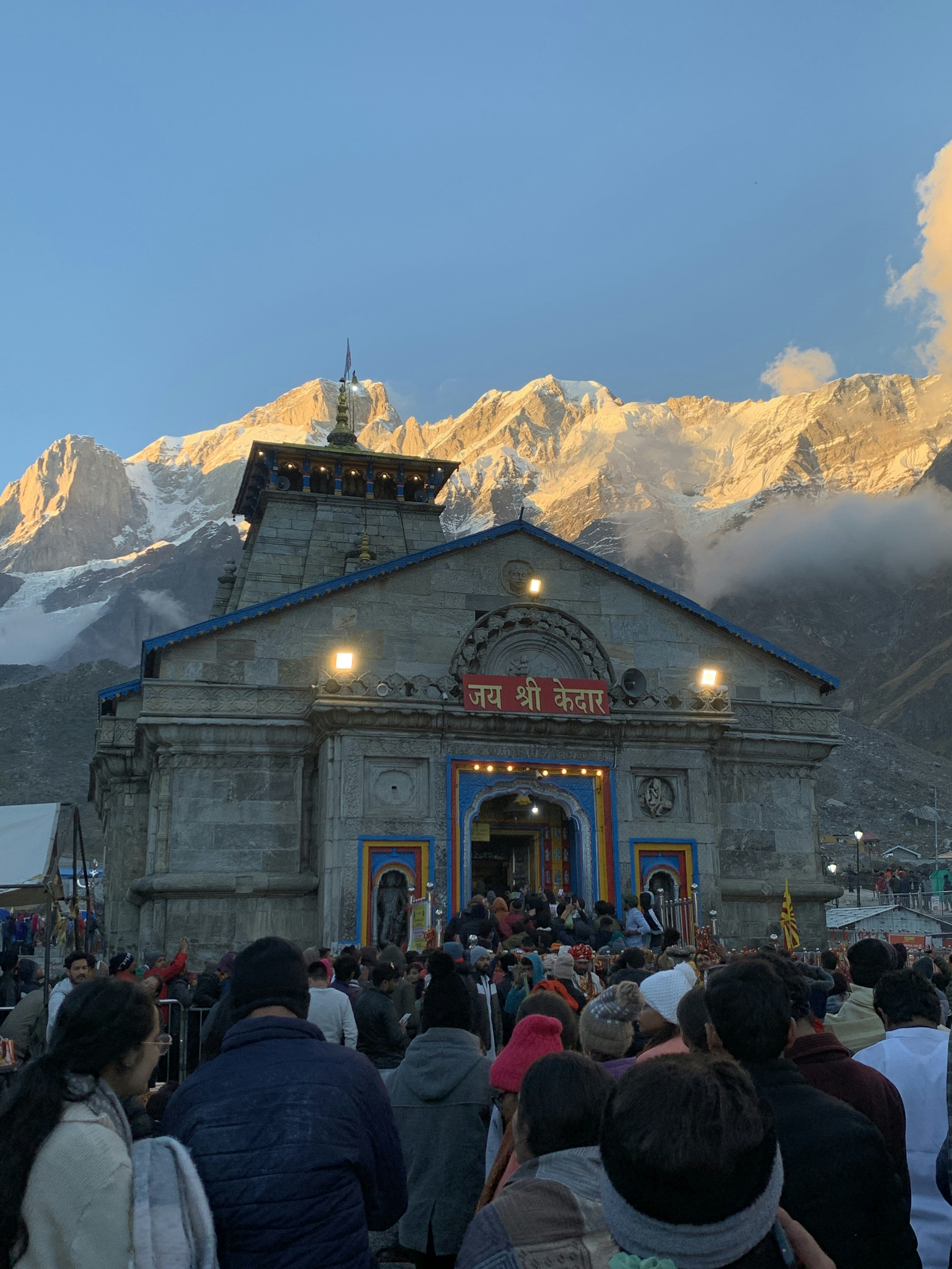 Sacred Kedarnath temple with devotees performing prayers during Char Dham pilgrimage journey