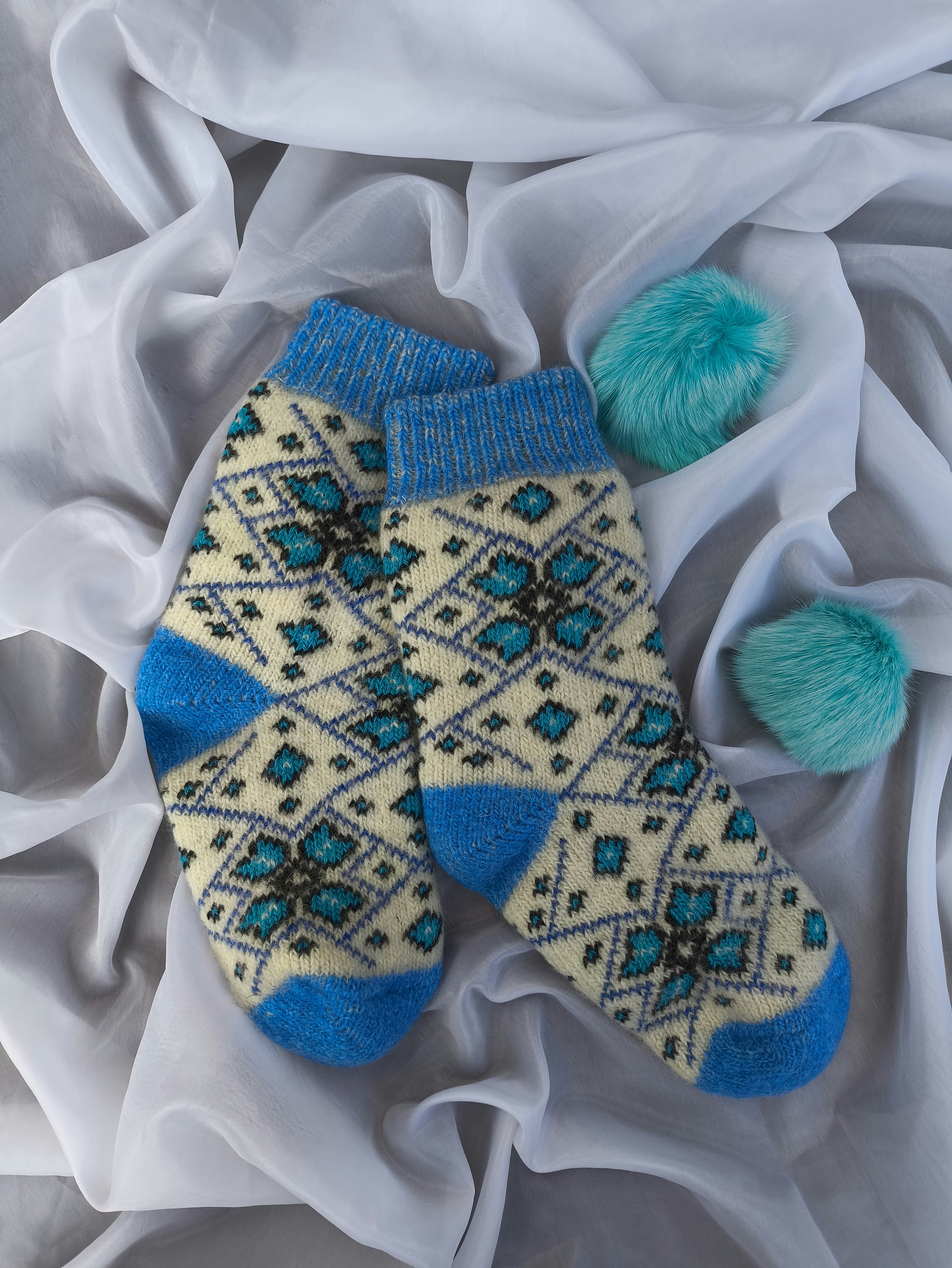 A pair of socks laying on top of a white sheet