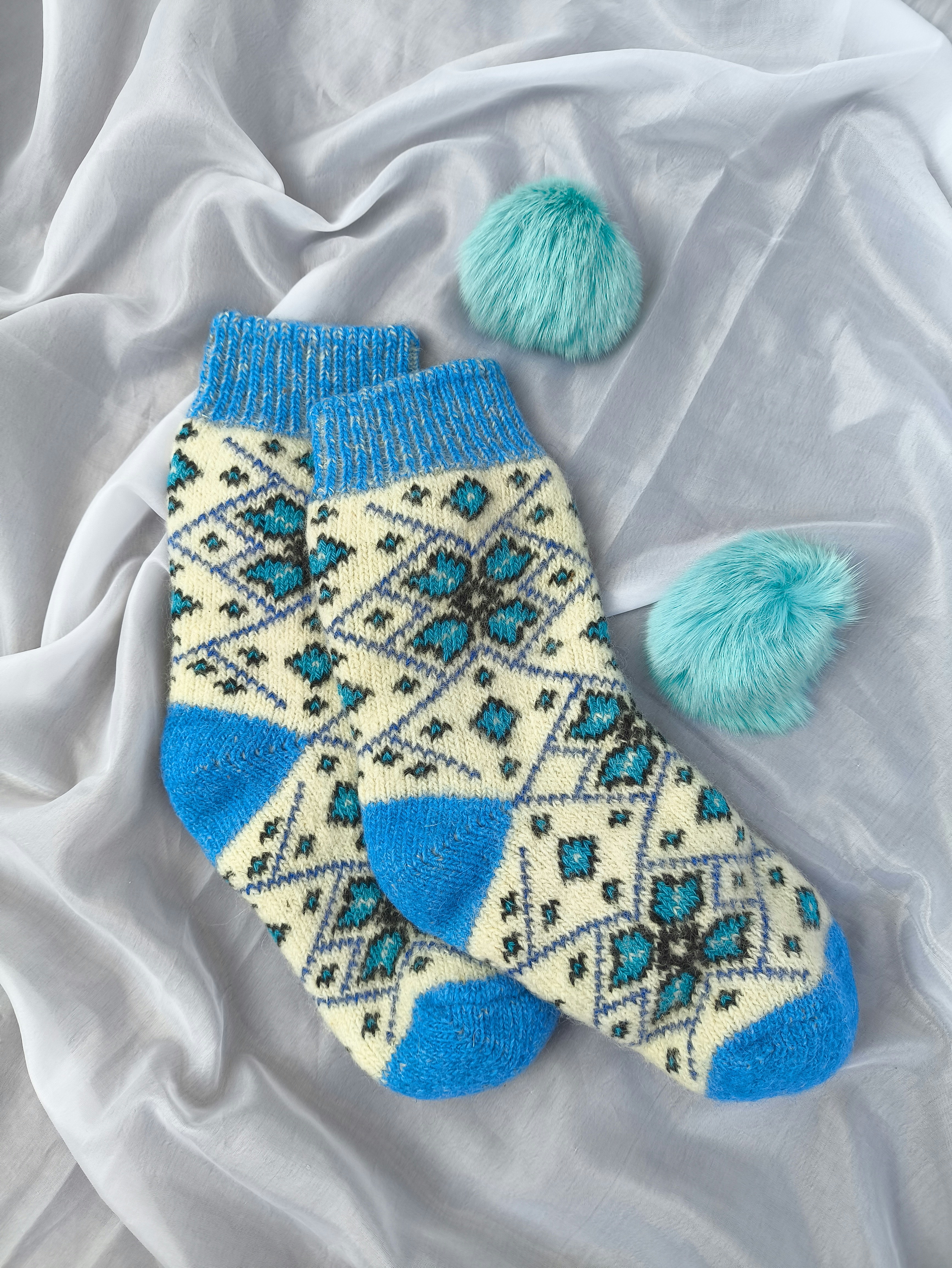 A pair of blue and white socks with pom poms
