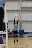 A person jumping up to hit a volleyball