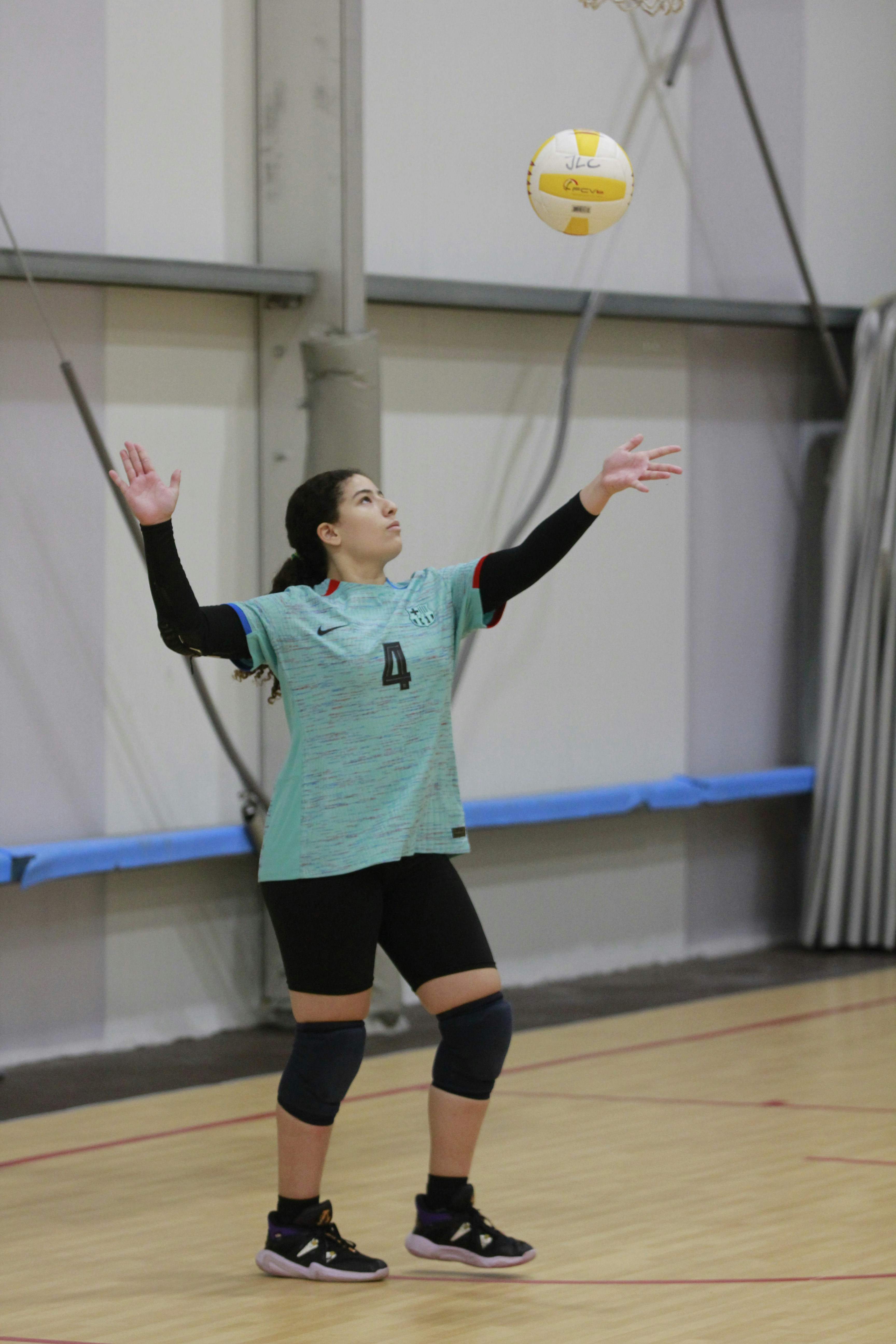 Eine Frau spielt Volleyball in einer Turnhalle