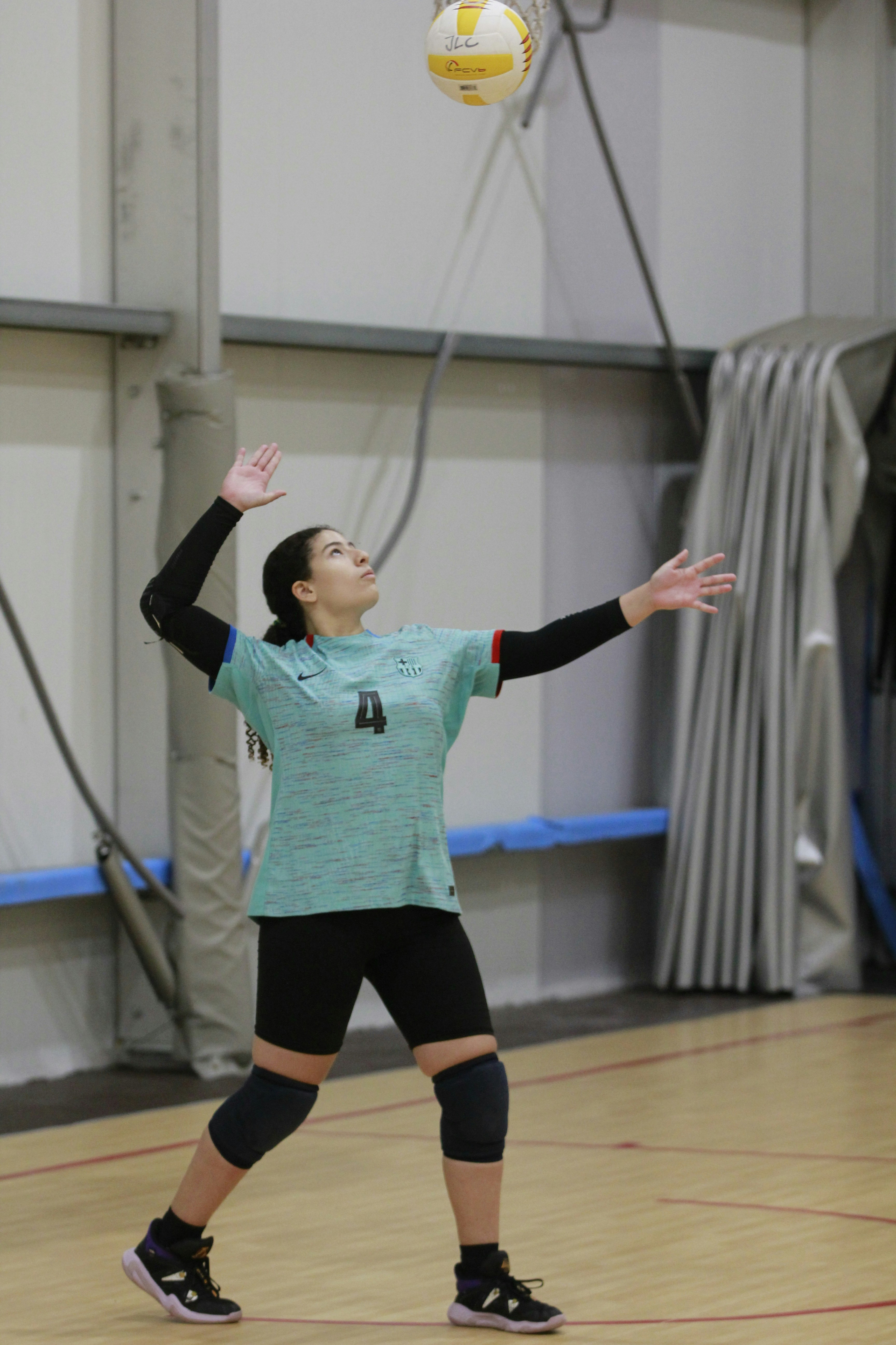 Eine Frau spielt Volleyball in einer Turnhalle