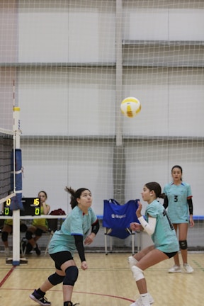 A group of young women playing a game of volleyball