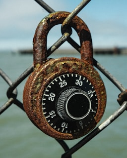 A padlock attached to a chain link fence