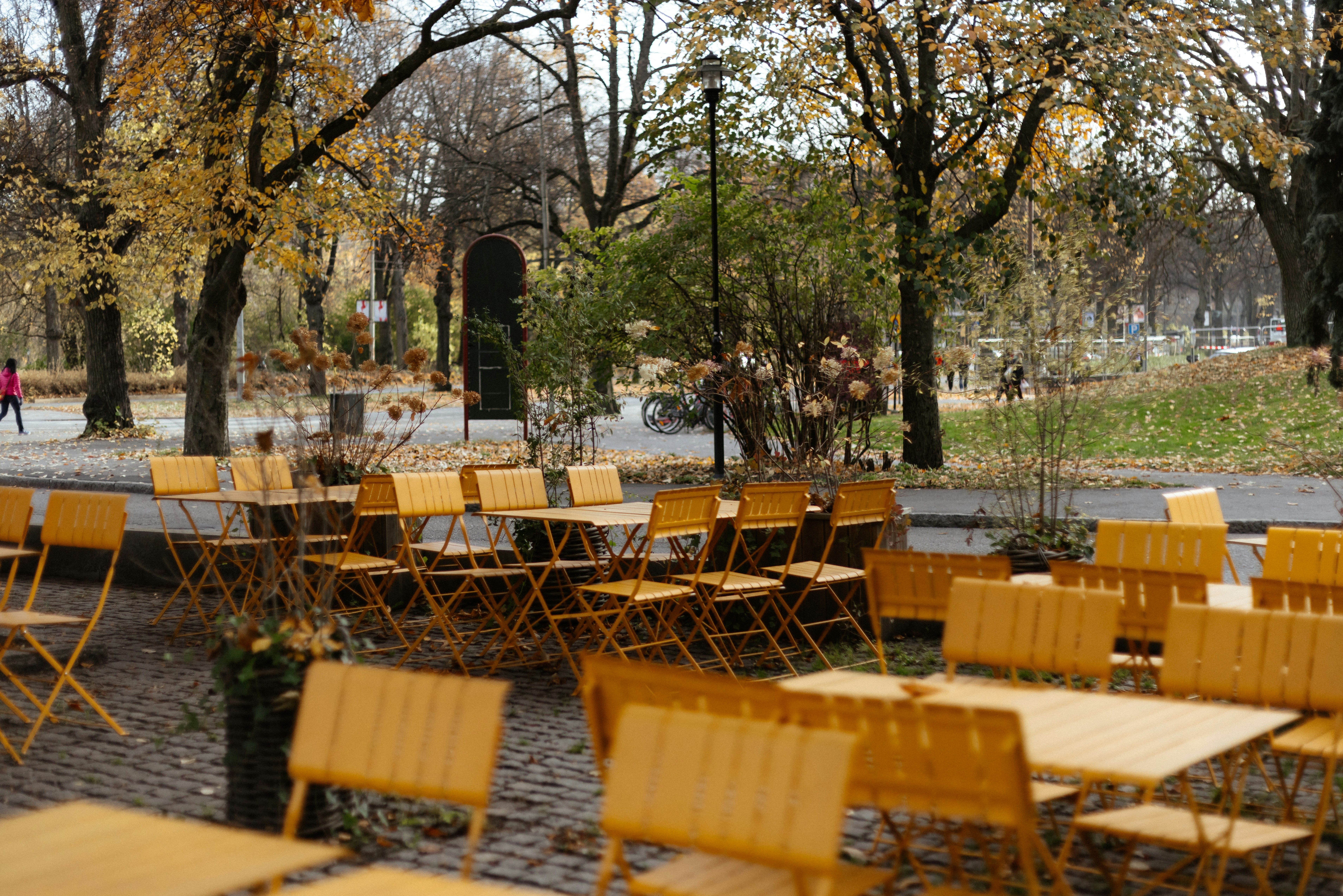 A group of wooden tables and chairs in a park