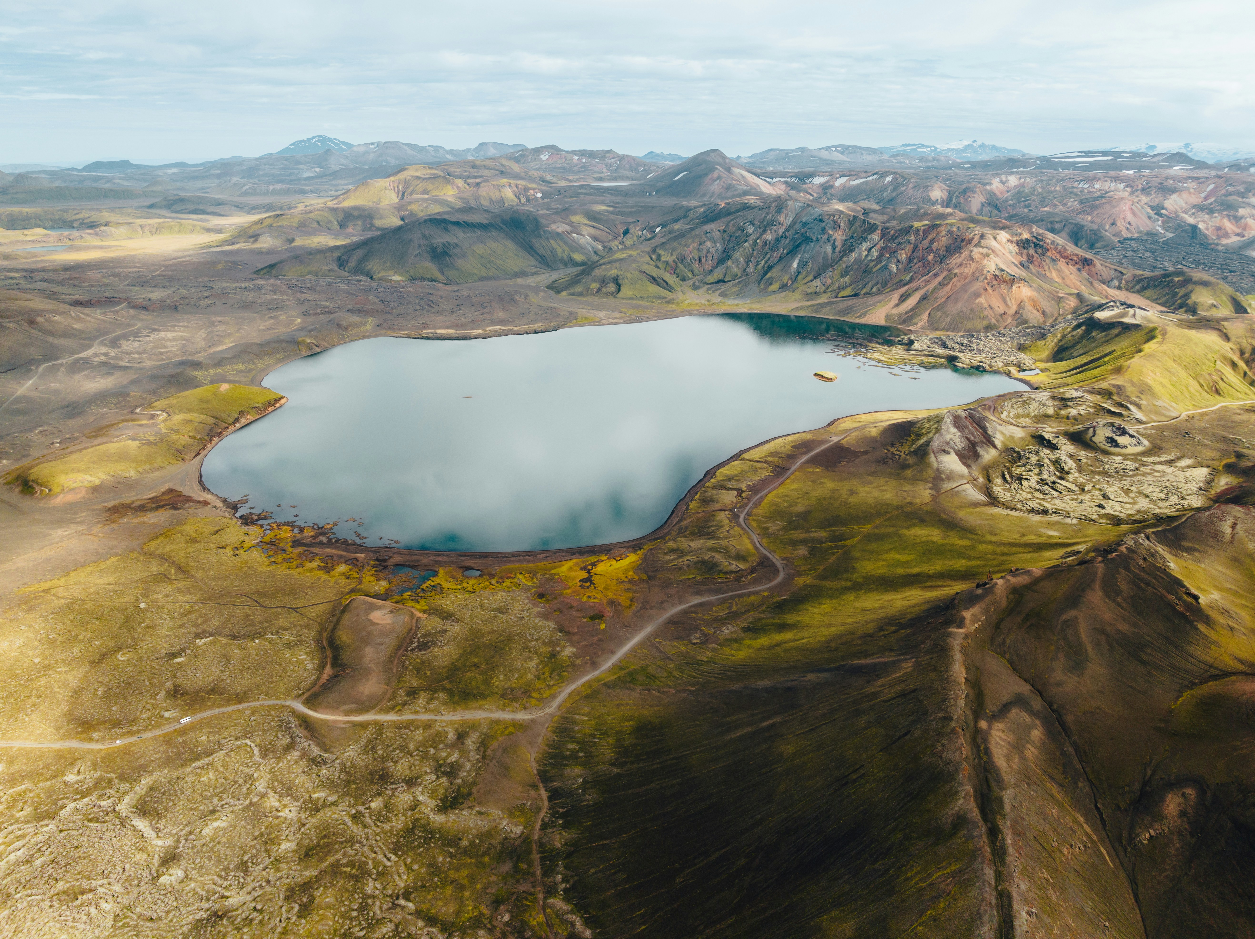 An aerial view of a lake surrounded by mountains