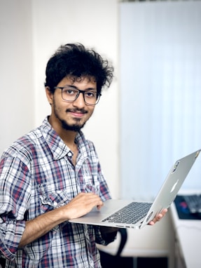 A man holding a laptop computer in his hand
