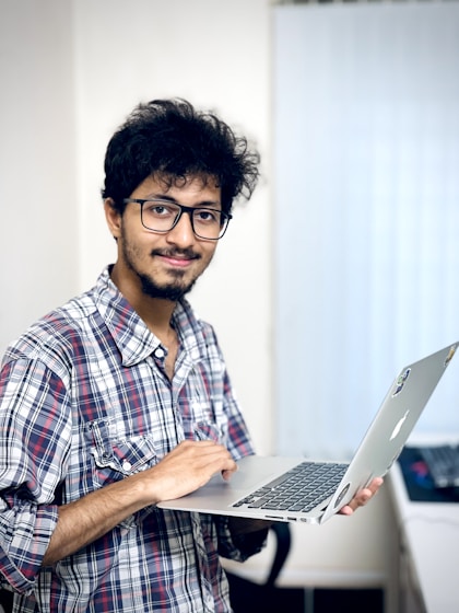 A man holding a laptop computer in his hand