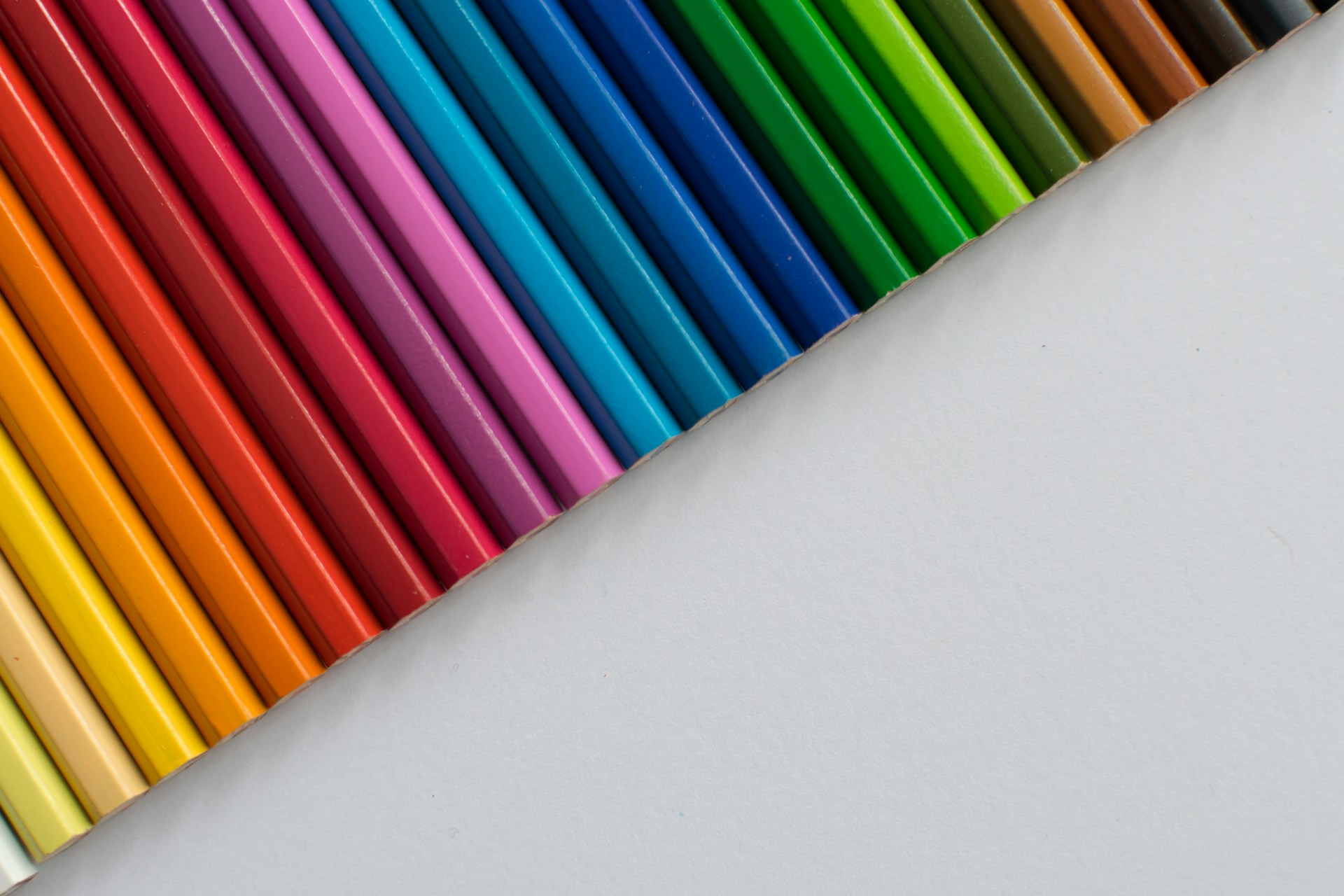 A row of colored pencils sitting next to each other