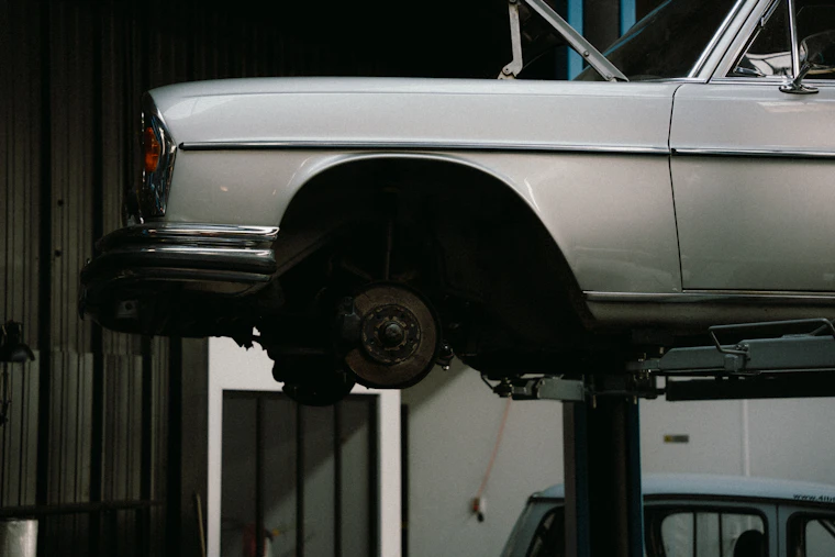 Classic car raised on a service lift for wheel work