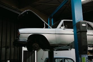 A white car on a lift in a garage