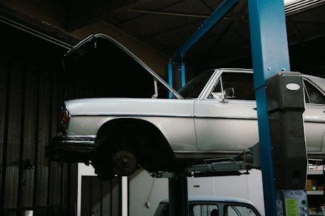 A white car on a lift in a garage
