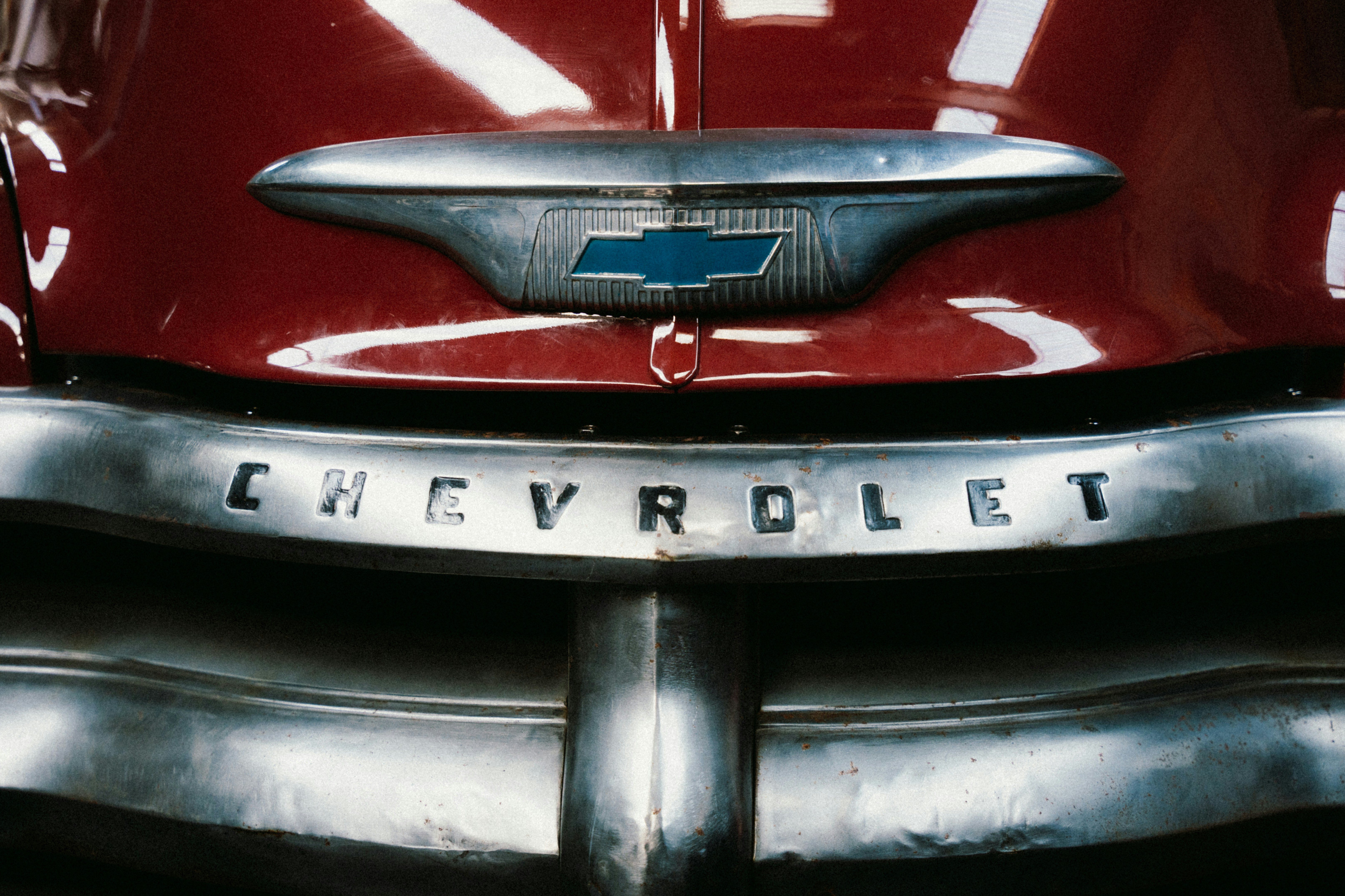 A close up of a chevrolet emblem on a red car photo – Free Logo Image ...