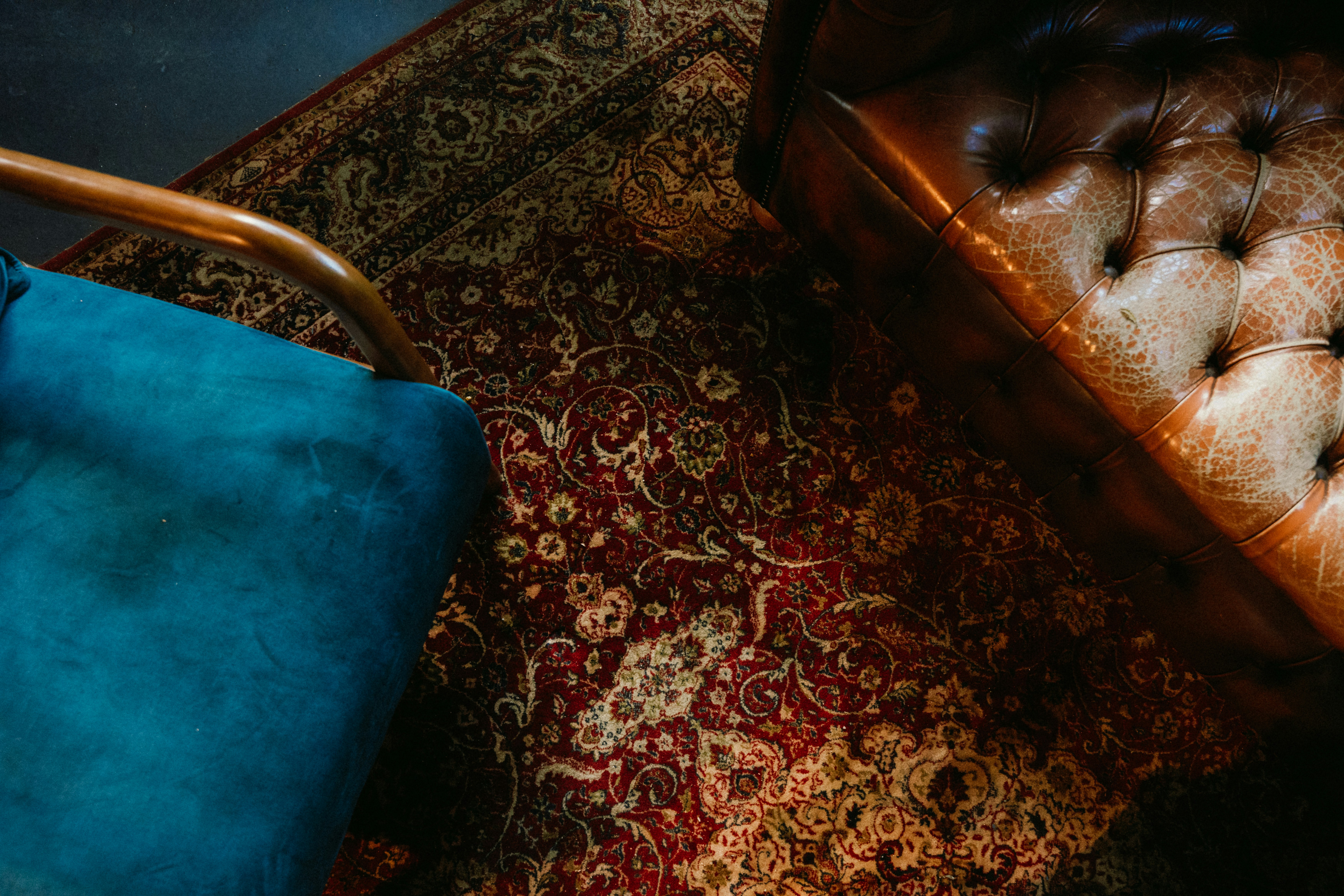 A brown leather bench sitting on top of a rug