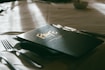 A table with a menu and silverware on it