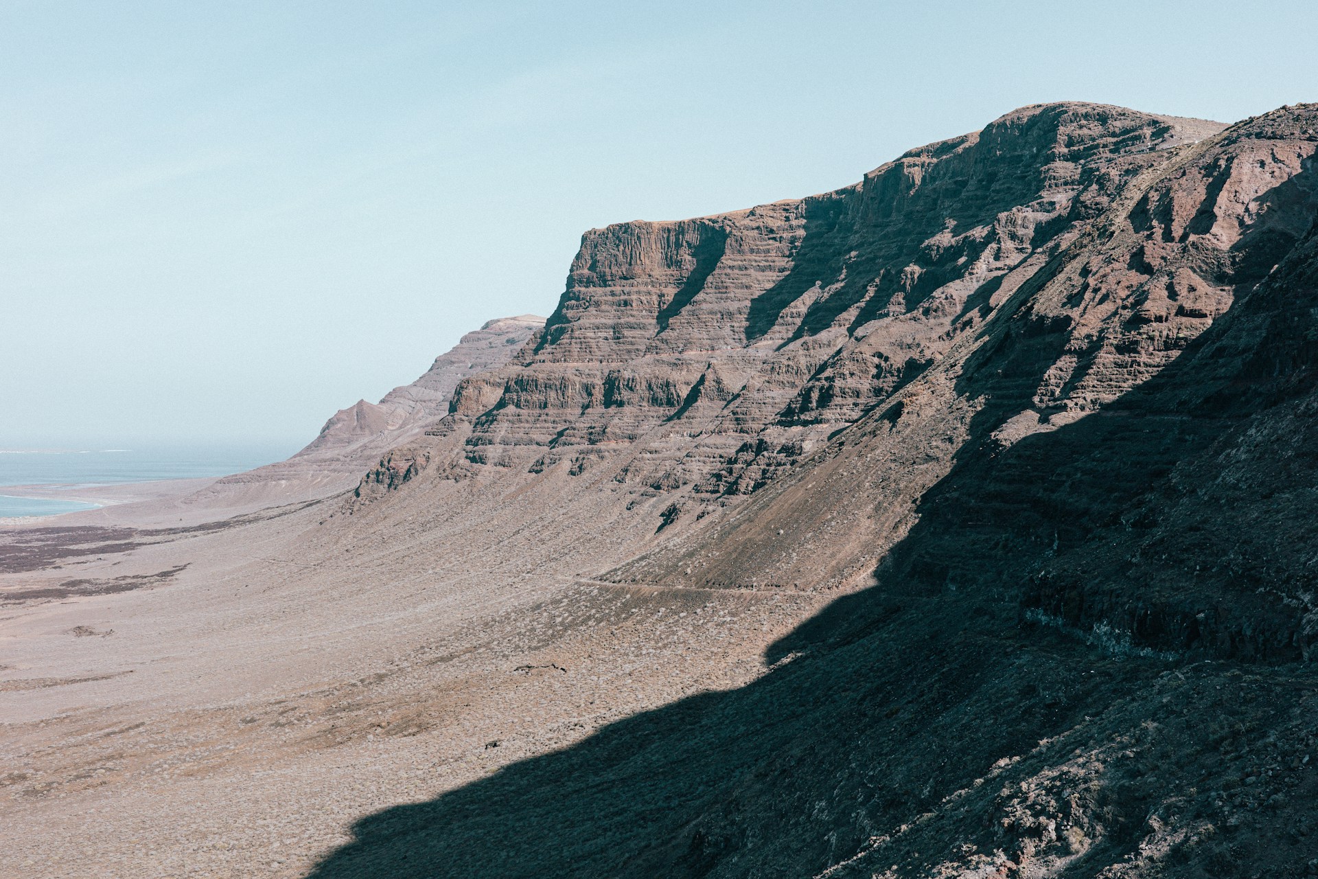A view of a mountain range from the top of a hill