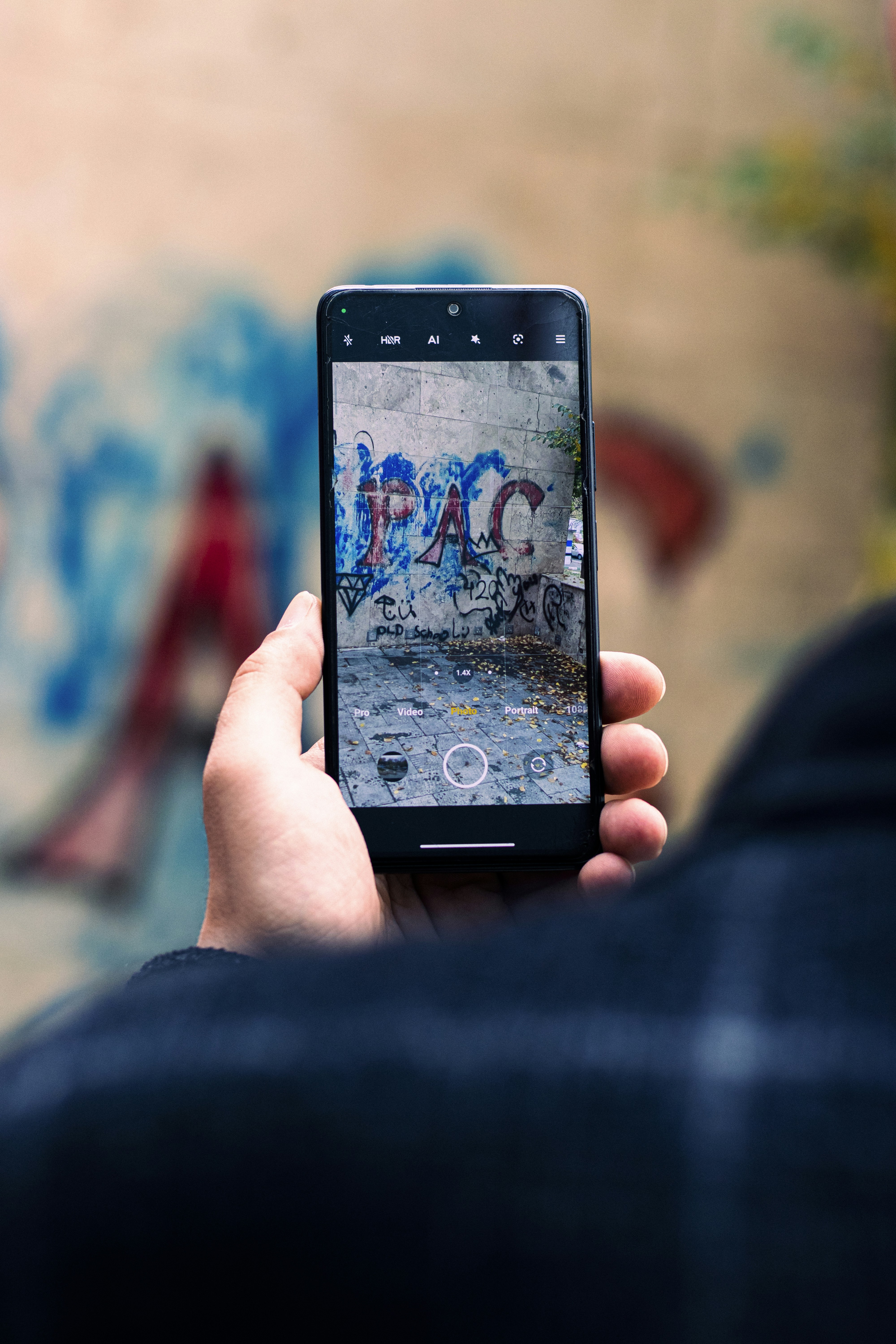 A person taking a picture of graffiti on a wall