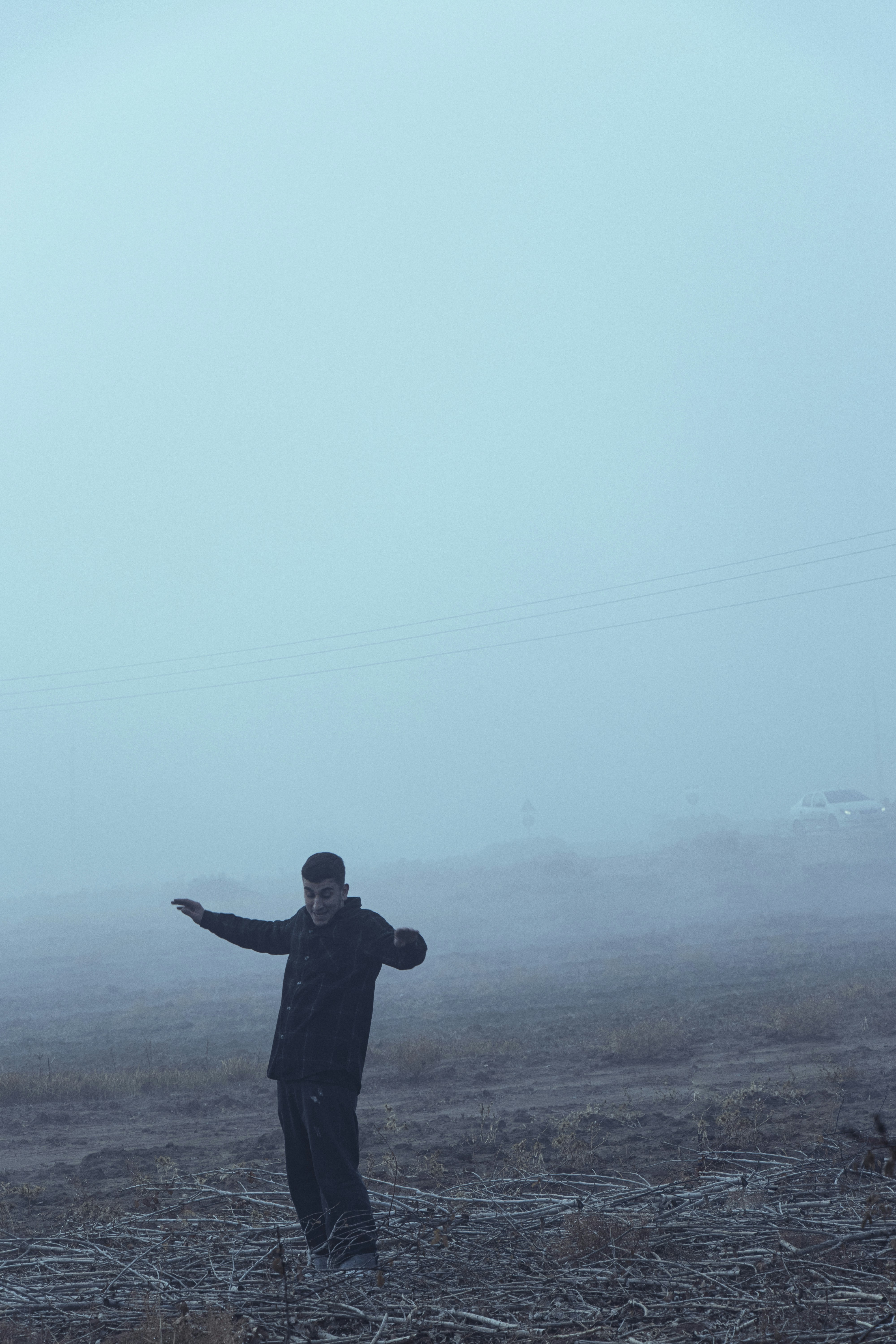 A man standing in the middle of a field in the fog