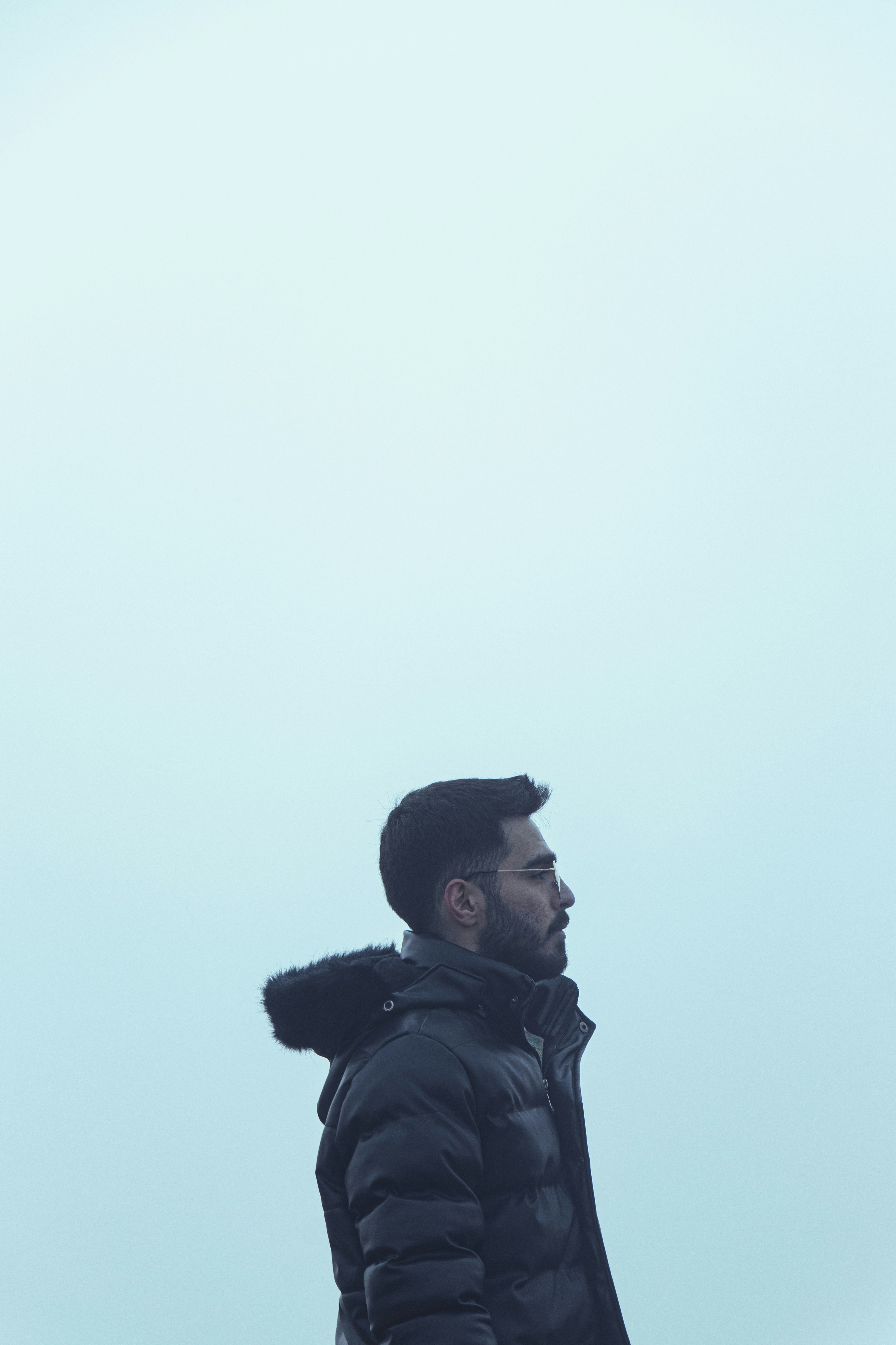 A man standing in front of a kite flying in the sky