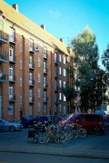 A group of bikes parked in front of a tall building