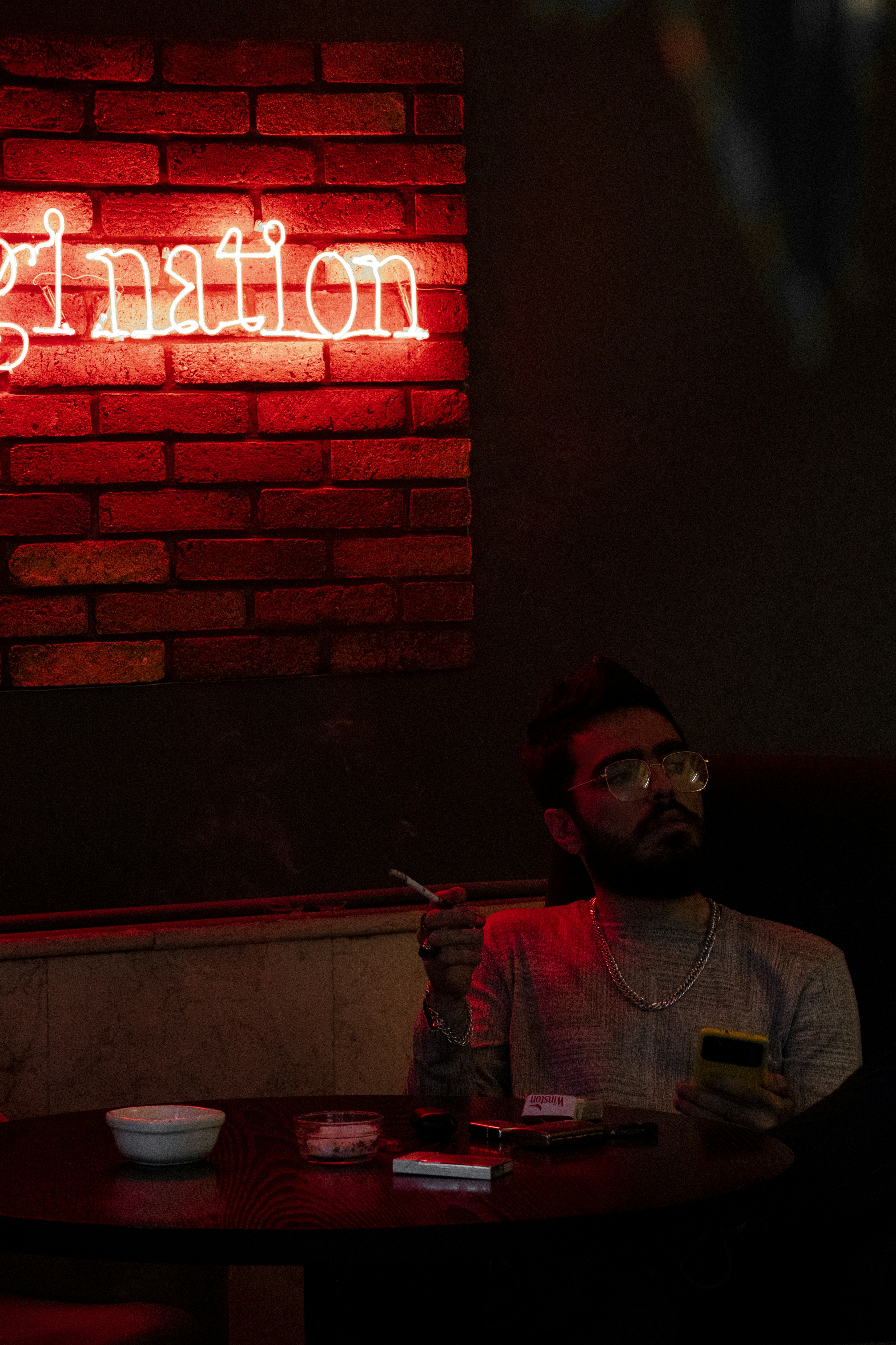 A man sitting at a table in front of a brick wall