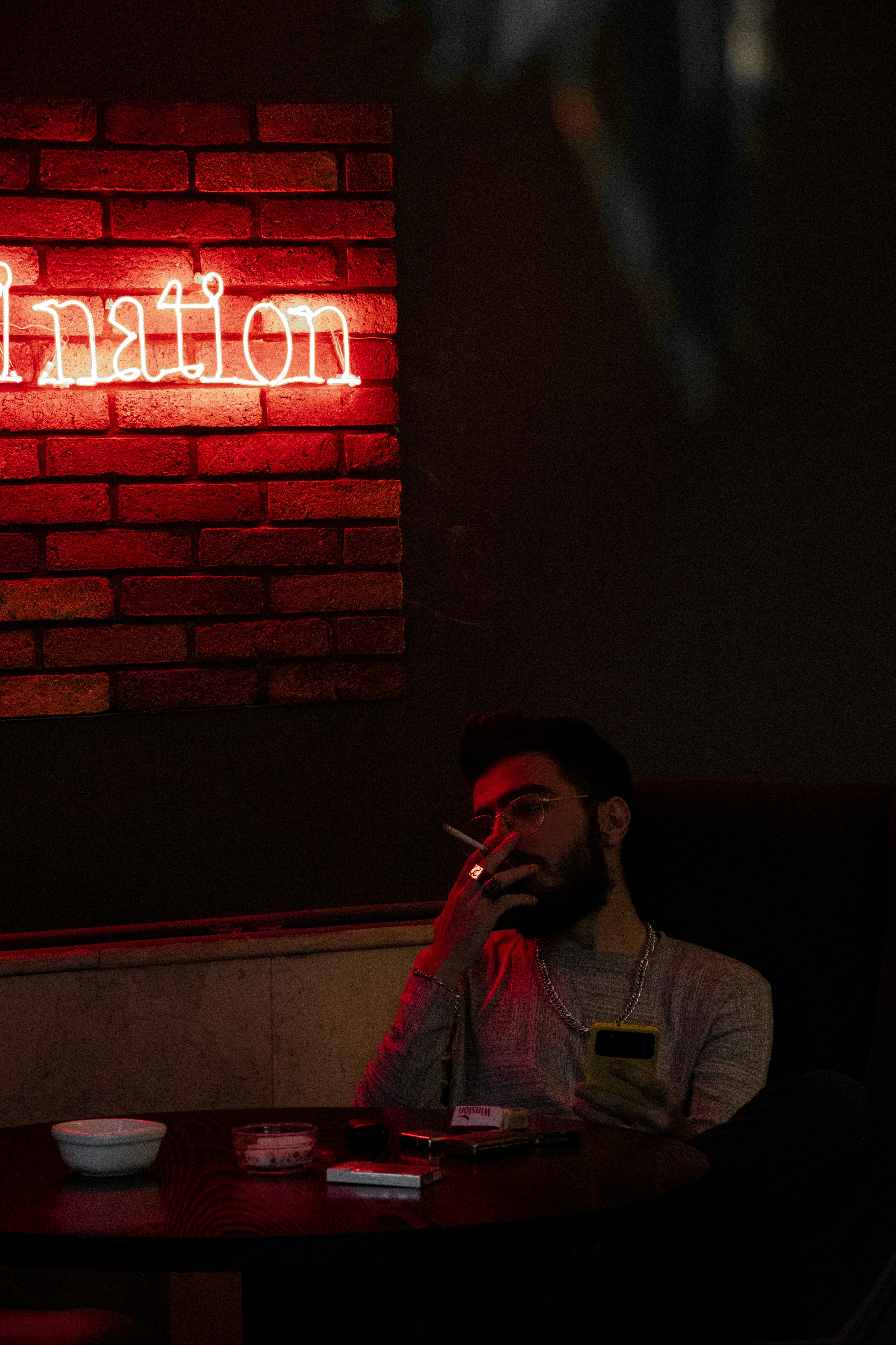 A man sitting at a table in front of a brick wall