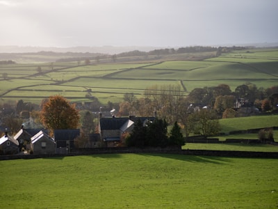 A green field with houses in the distance