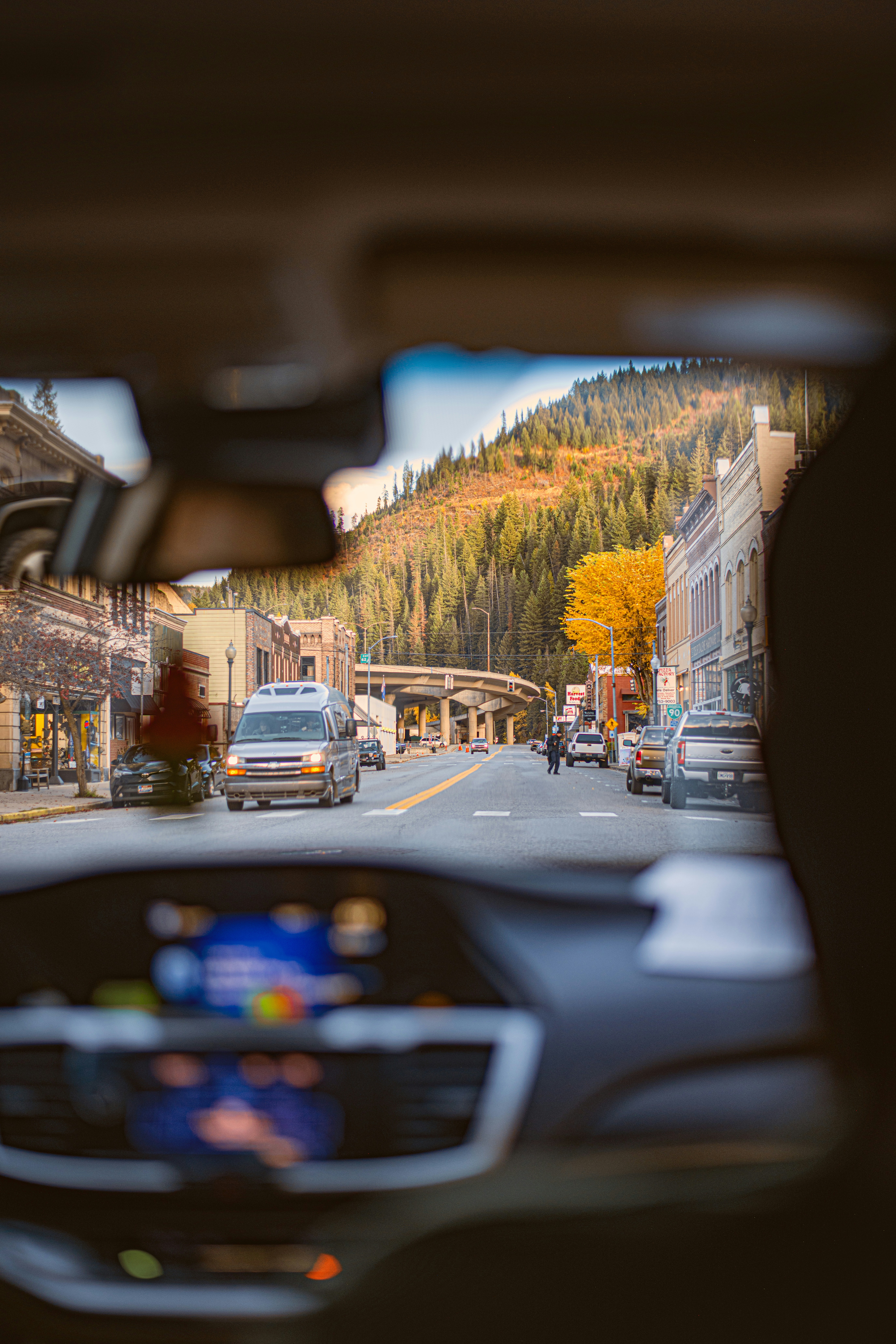 A view from inside a car of a street with a mountain in the background