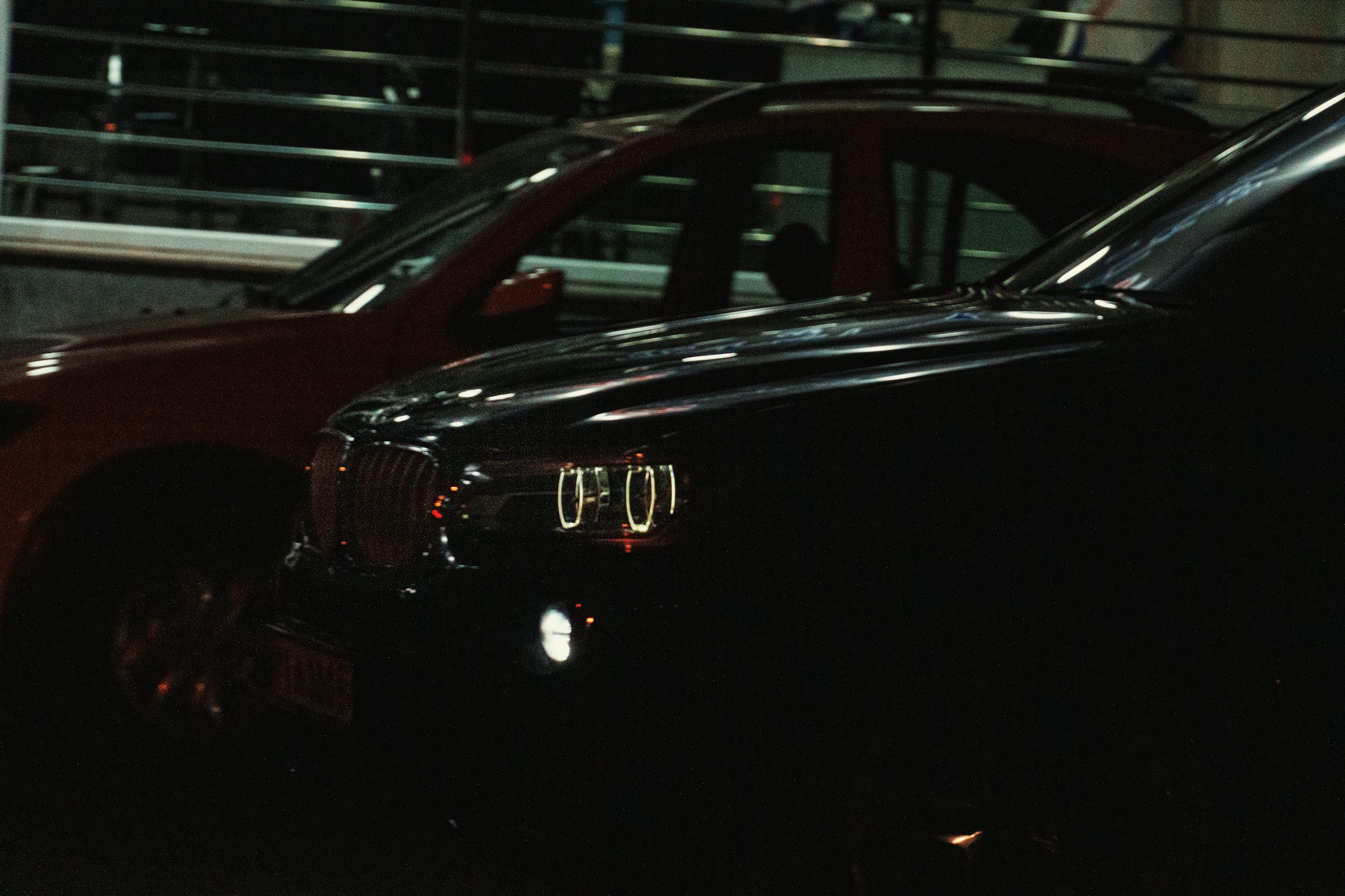 A car parked in a parking garage next to another car