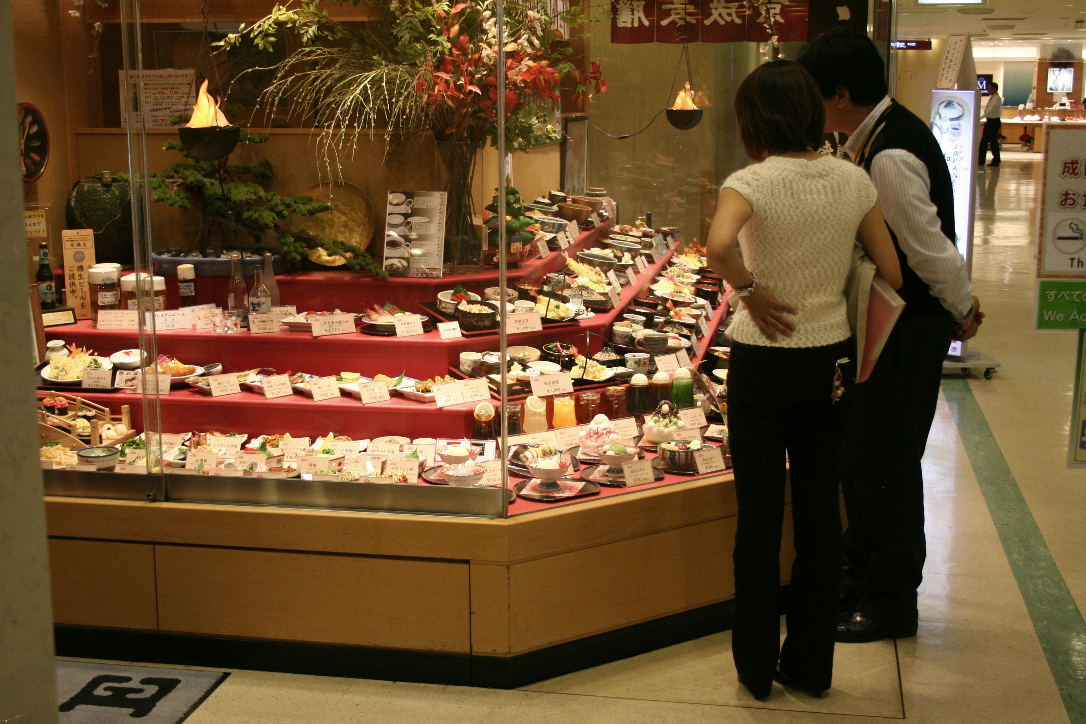 customer looking at fresh ingredients - sandwich prep table with glass sneeze guard