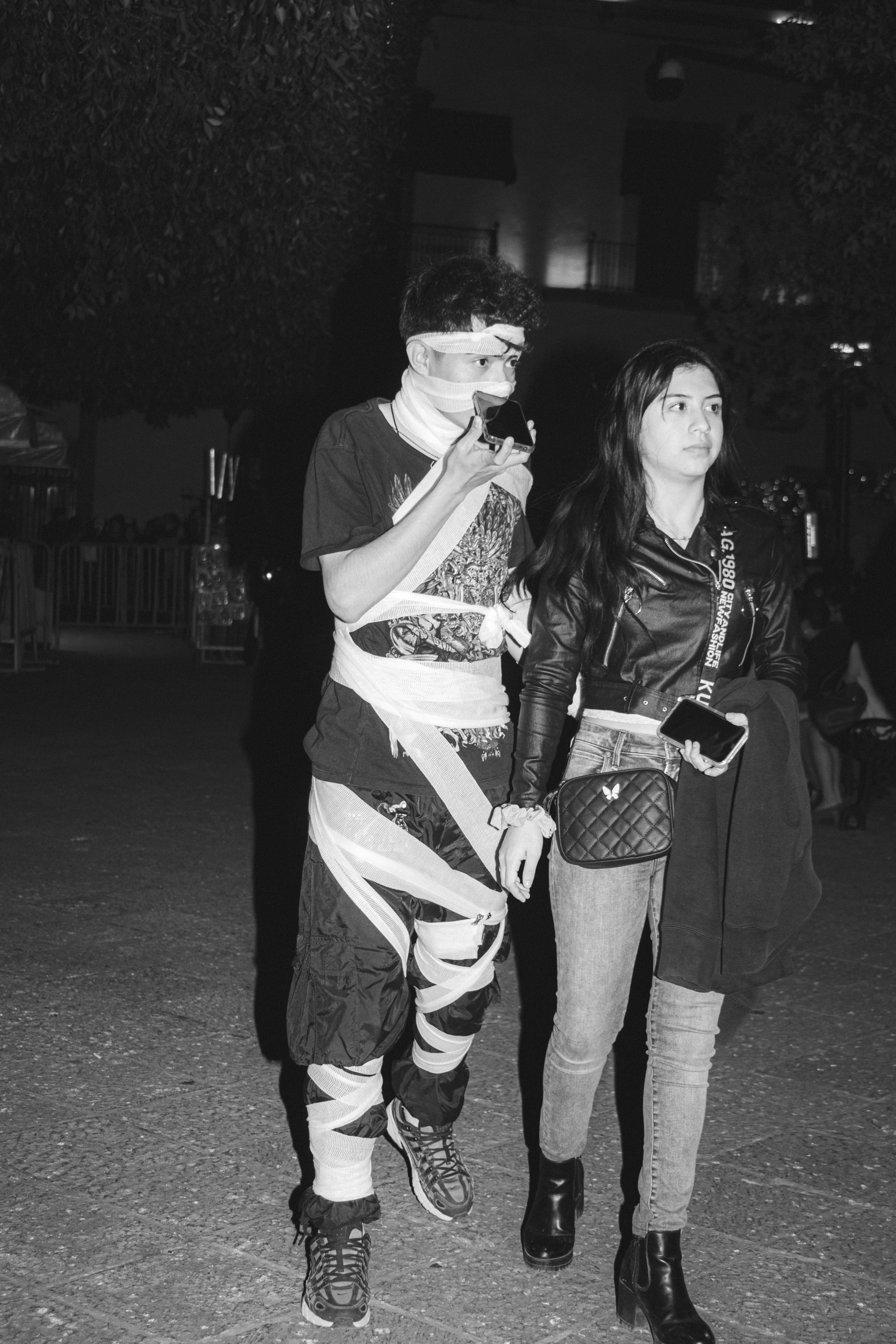 Seorang pria dan seorang wanita berjalan di jalan di malam hari