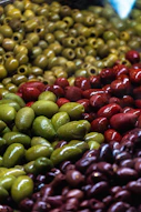 A display of olives and other fruits in a store