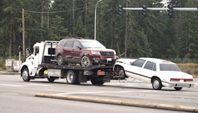 A tow truck towing a car on the road