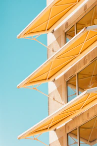 A tall building with yellow umbrellas on top of it