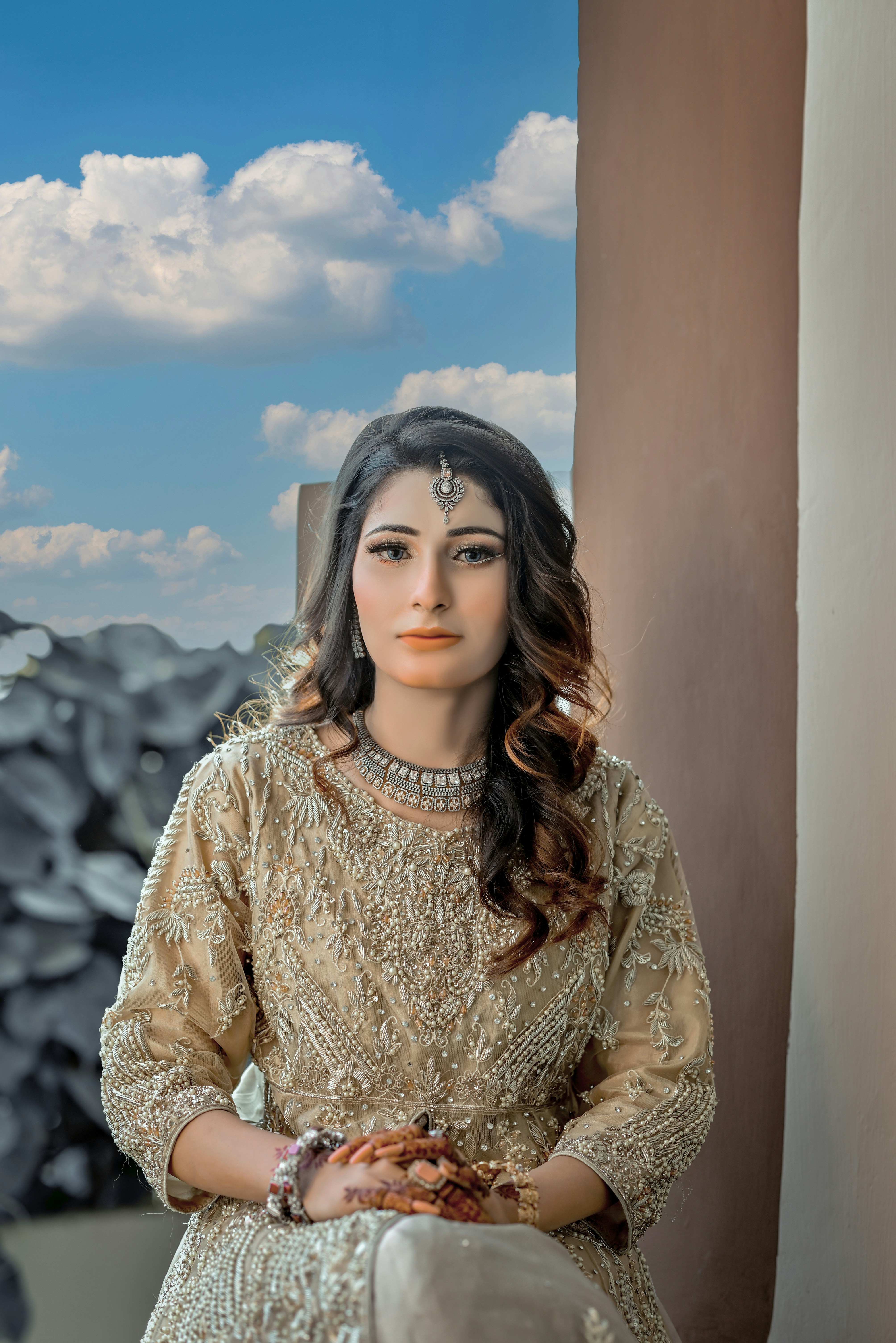 A woman in a white dress standing next to a wall